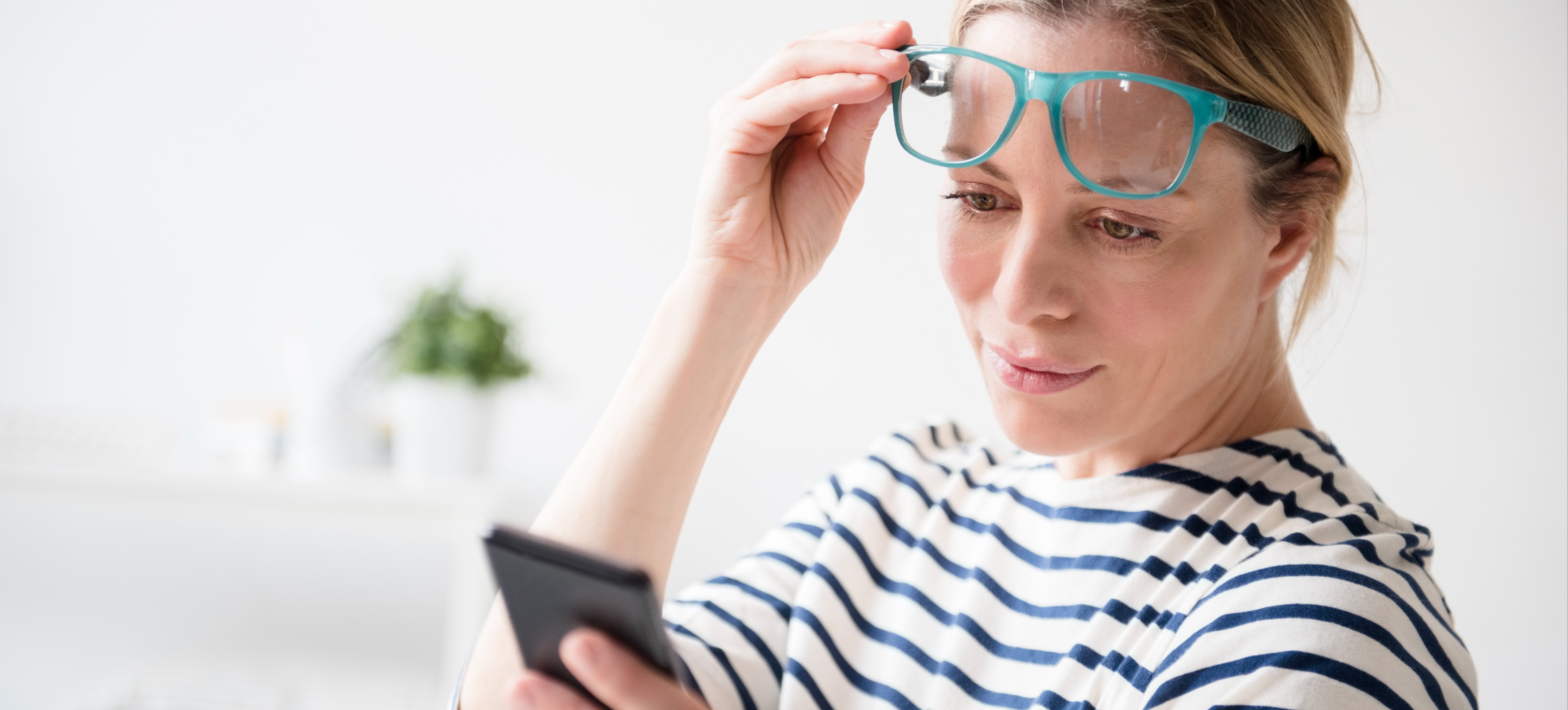 [Featured Image] A person unlocks their smartphone using facial recognition, one of many examples of computer vision applications.
