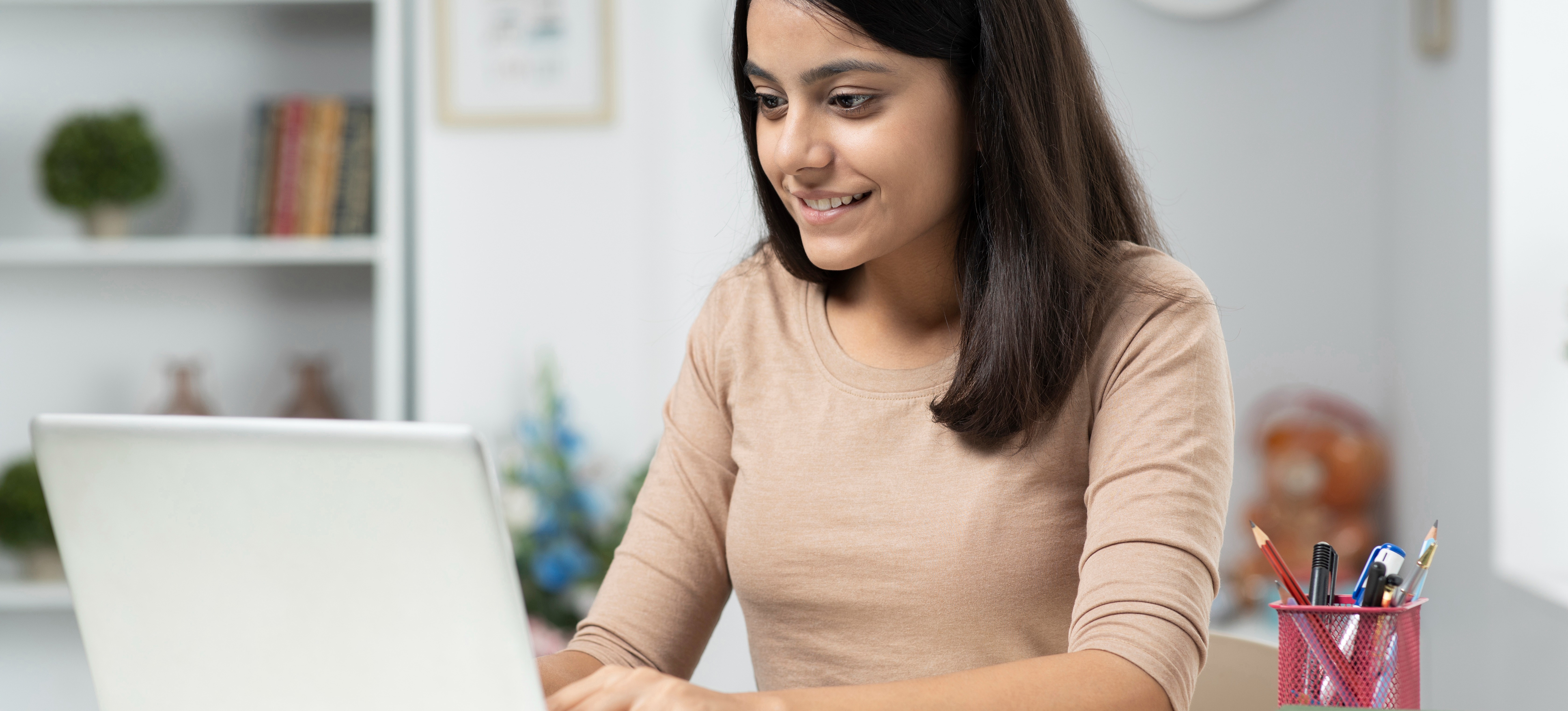 [Featured Image]: A young woman using a laptop practises using the skills she needs for a career in computer engineering.