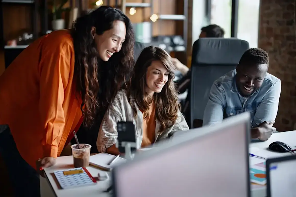 [Featured image] A UX Designer in a red sweater works on a mockup on a laptop computer.