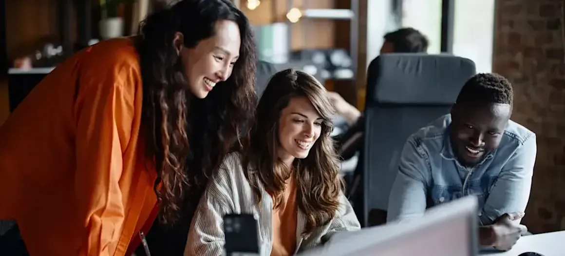 [Featured image] A UX Designer in a red sweater works on a mockup on a laptop computer.