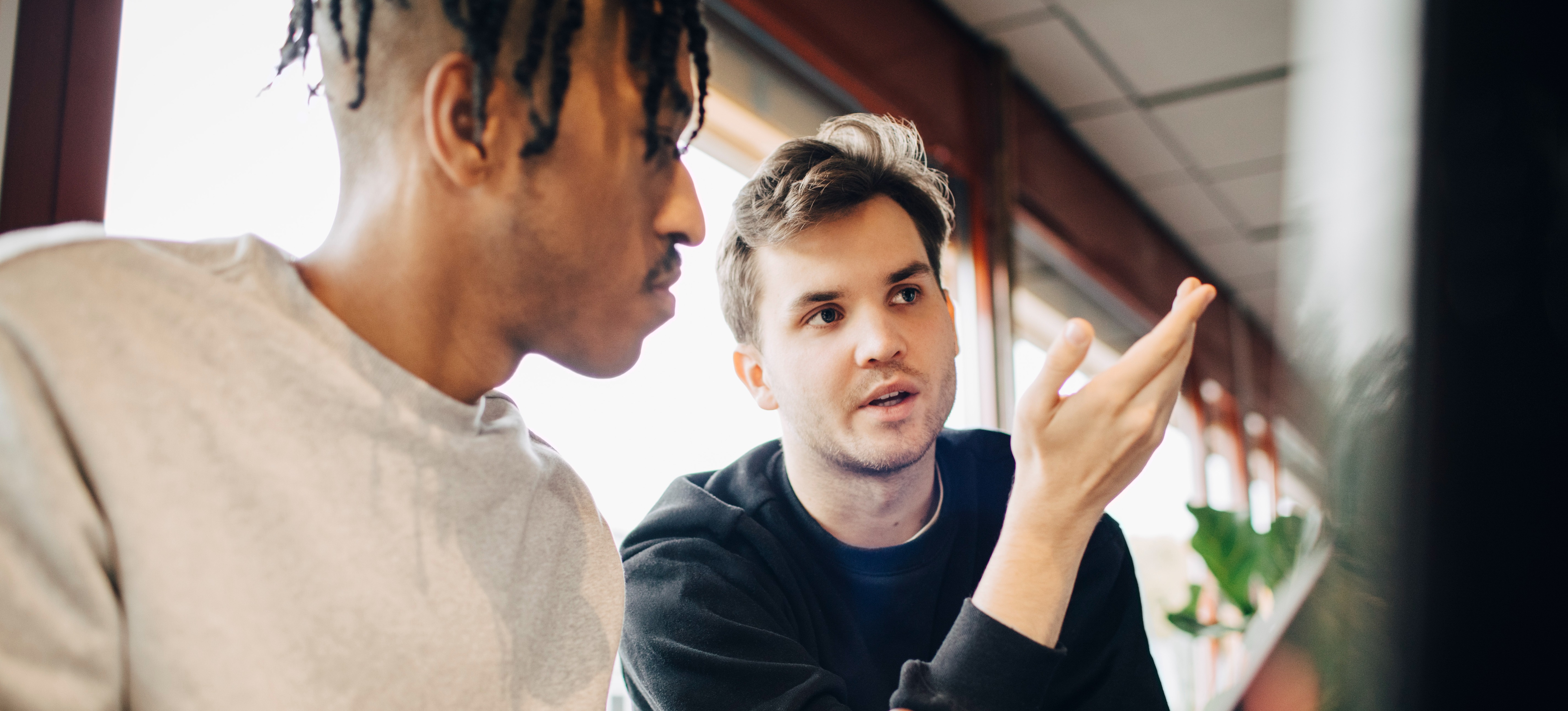 [Featured Image] Two computer programmers discuss the abstraction layers they must implement within the program they are creating.