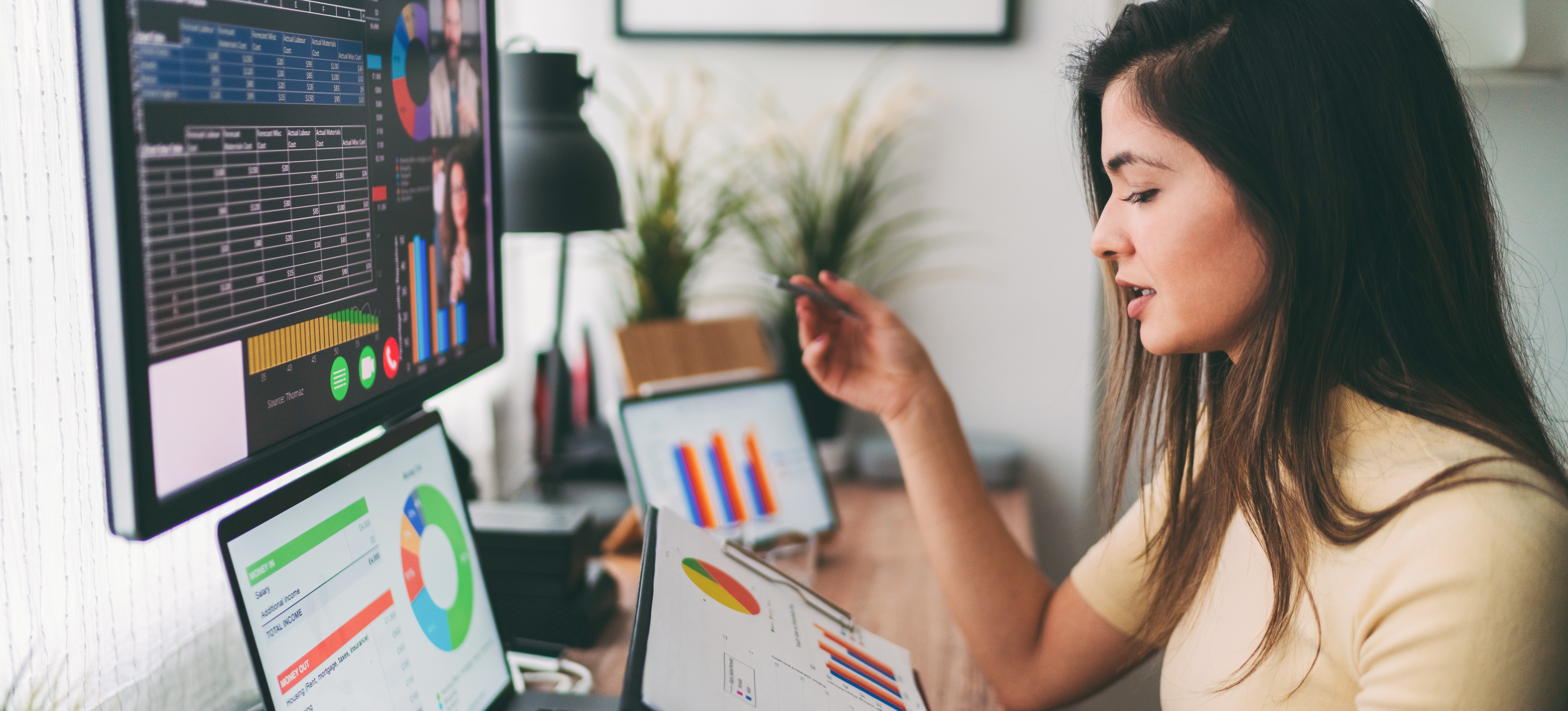 [Featured Image] An analyst with financial analyst certification credentials works from their home office, participating in a virtual meeting with financial charts displayed on the computer screen.
