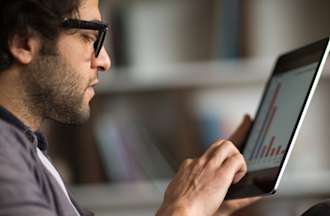 [Featured image] A data scientist works on a data model on a tablet.