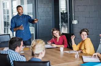 [Featured image] A man in a blue shirt leads a DevOps meeting.