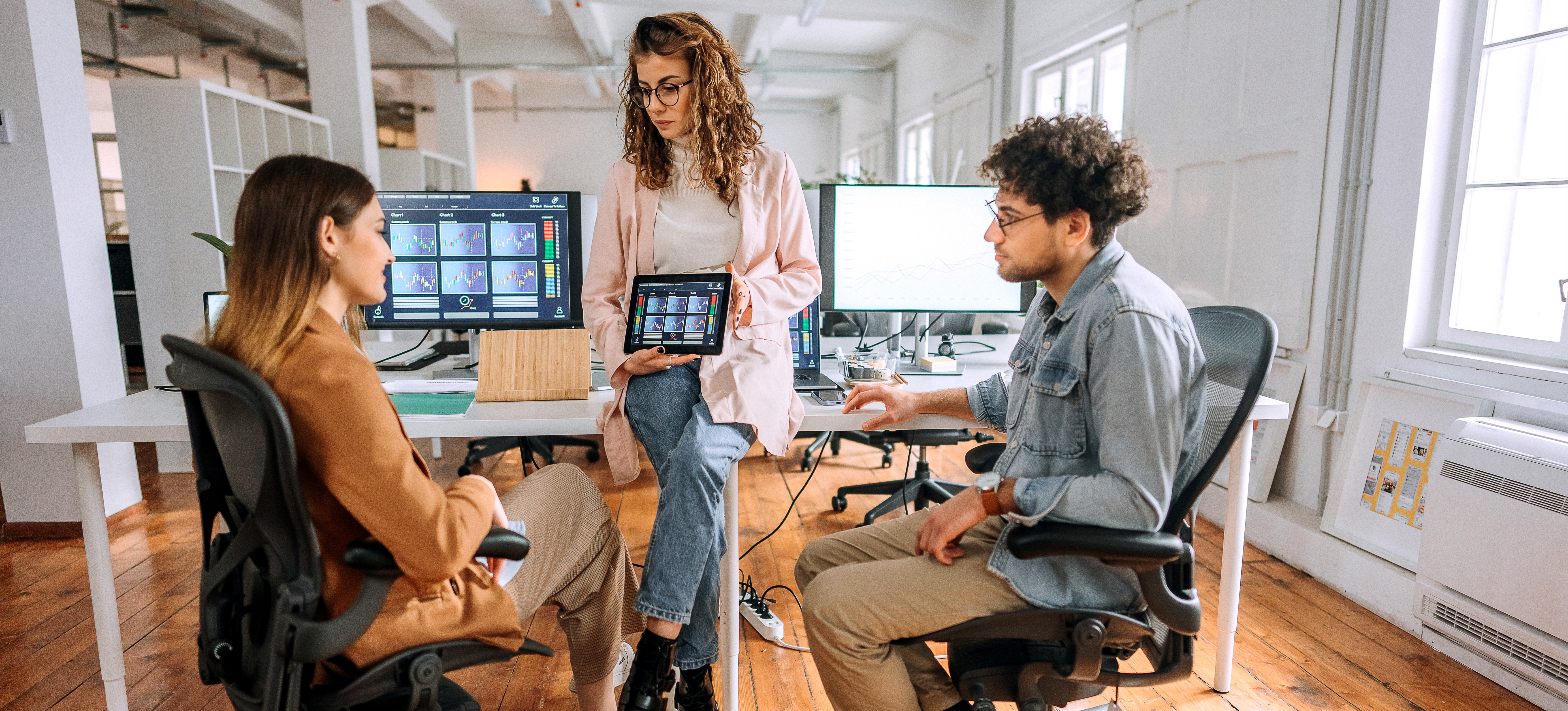 [Featured Image] A data visualization engineer presents graphic data to a team of colleagues.

