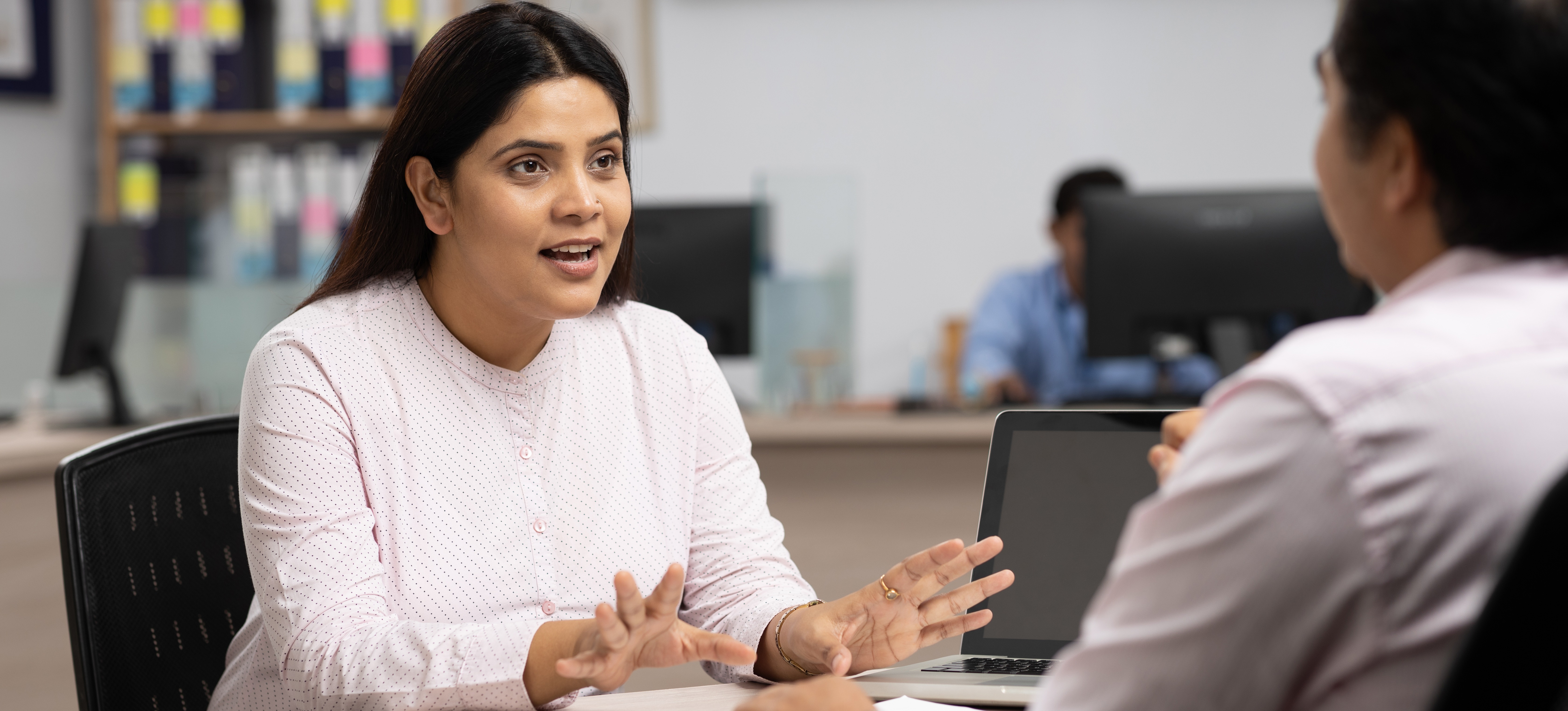 [Hauptbild] Eine Person nutzt Konfliktlösungsfähigkeiten, wenn sie mit einem Kollegen eine Situation am Arbeitsplatz bespricht.