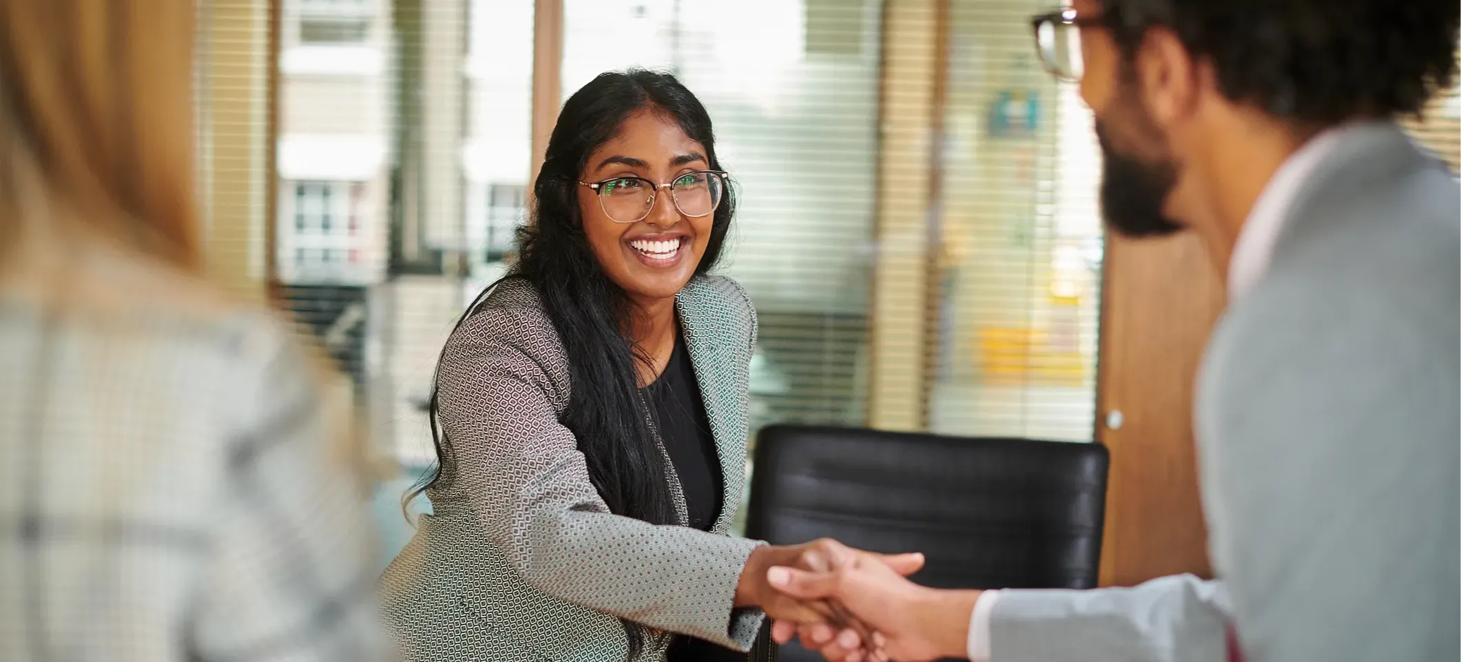 [Featured Image] Two senior computer engineers conduct a job interview with a candidate seeking a computer engineering role. 

