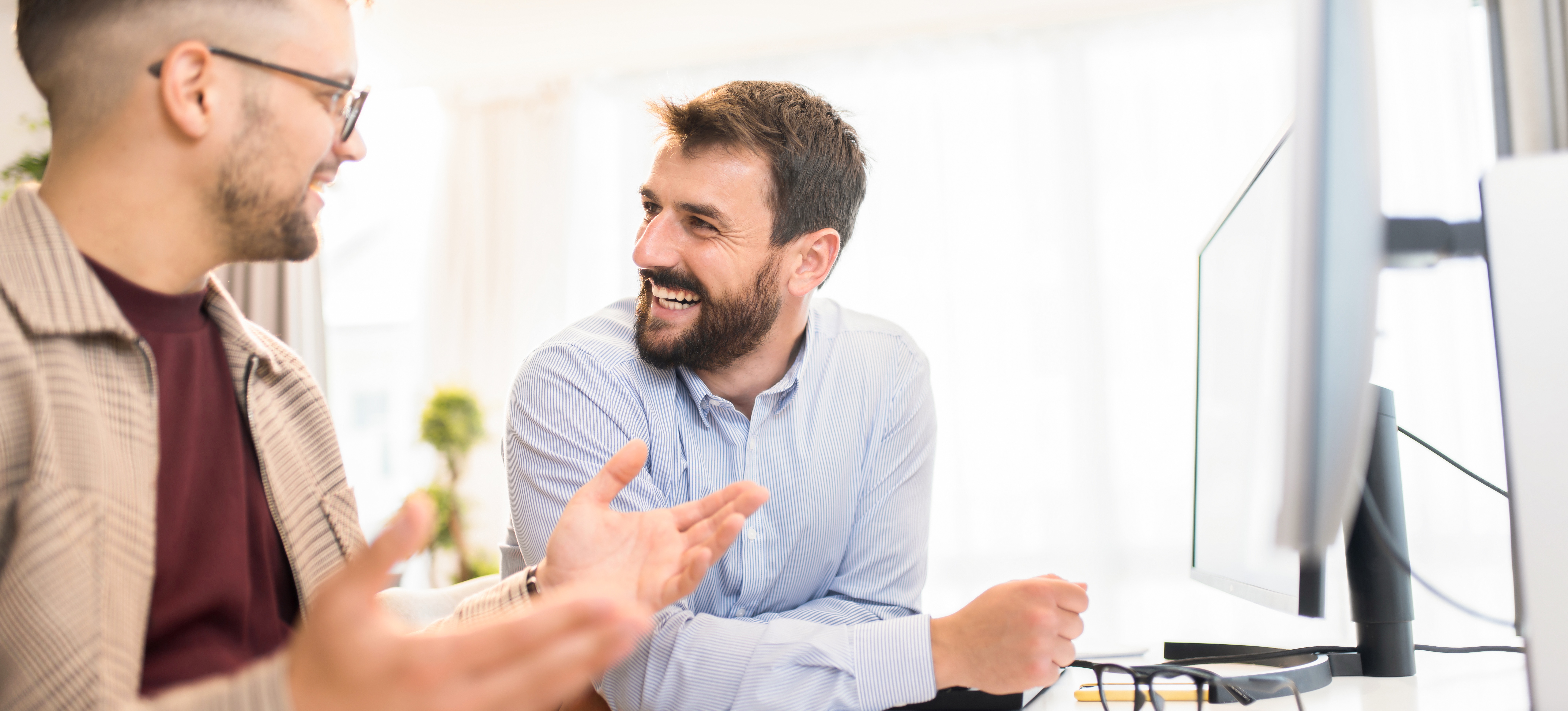 [Featured Image] Colleagues in a professional workspace, smiling and discussing how to become professionally certified in Web3.
