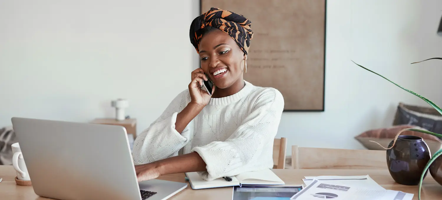 [Featured Image] A programmer sits at home, talks on the phone, and uses their laptop to research ads for R programming jobs. 
