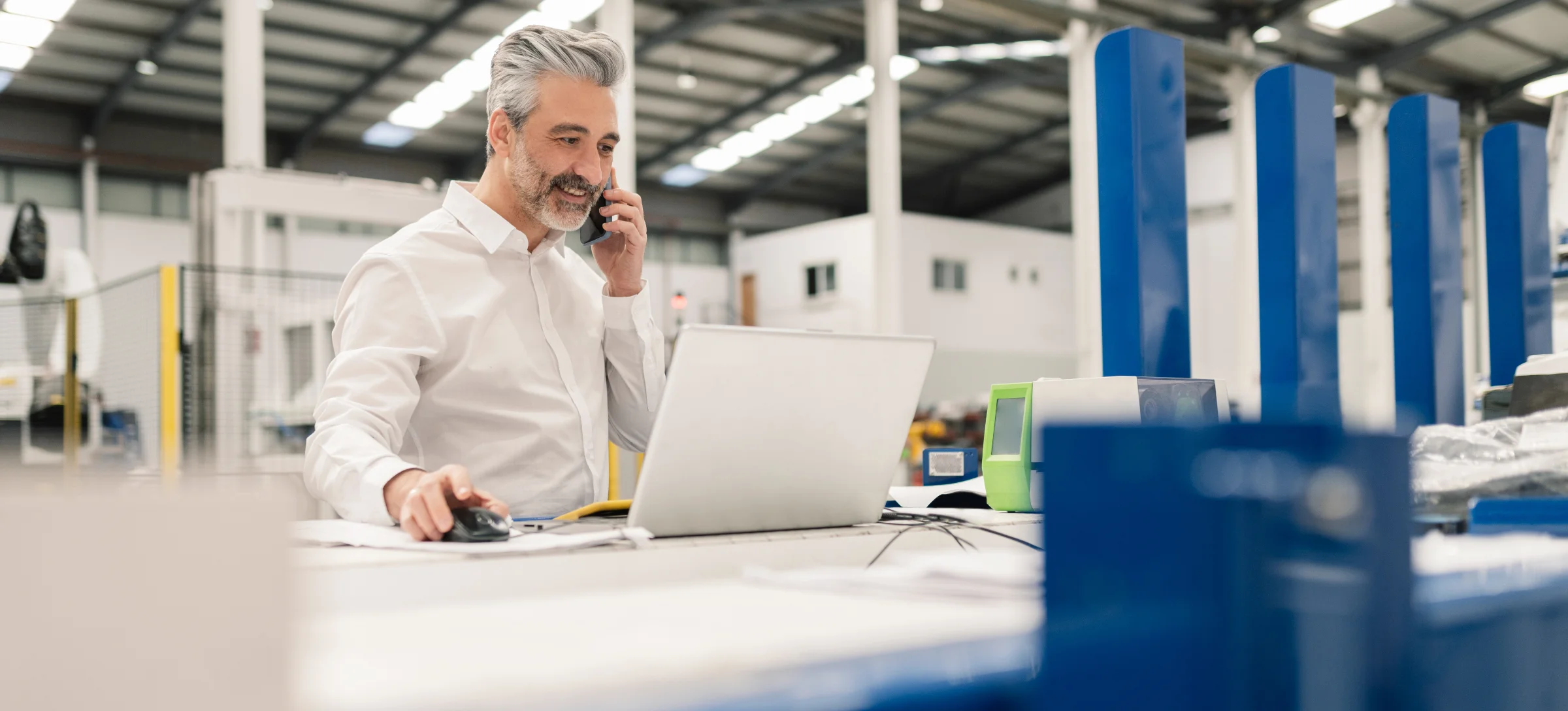 [Featured image] A technical sales engineer talks on a phone while working on a computer.