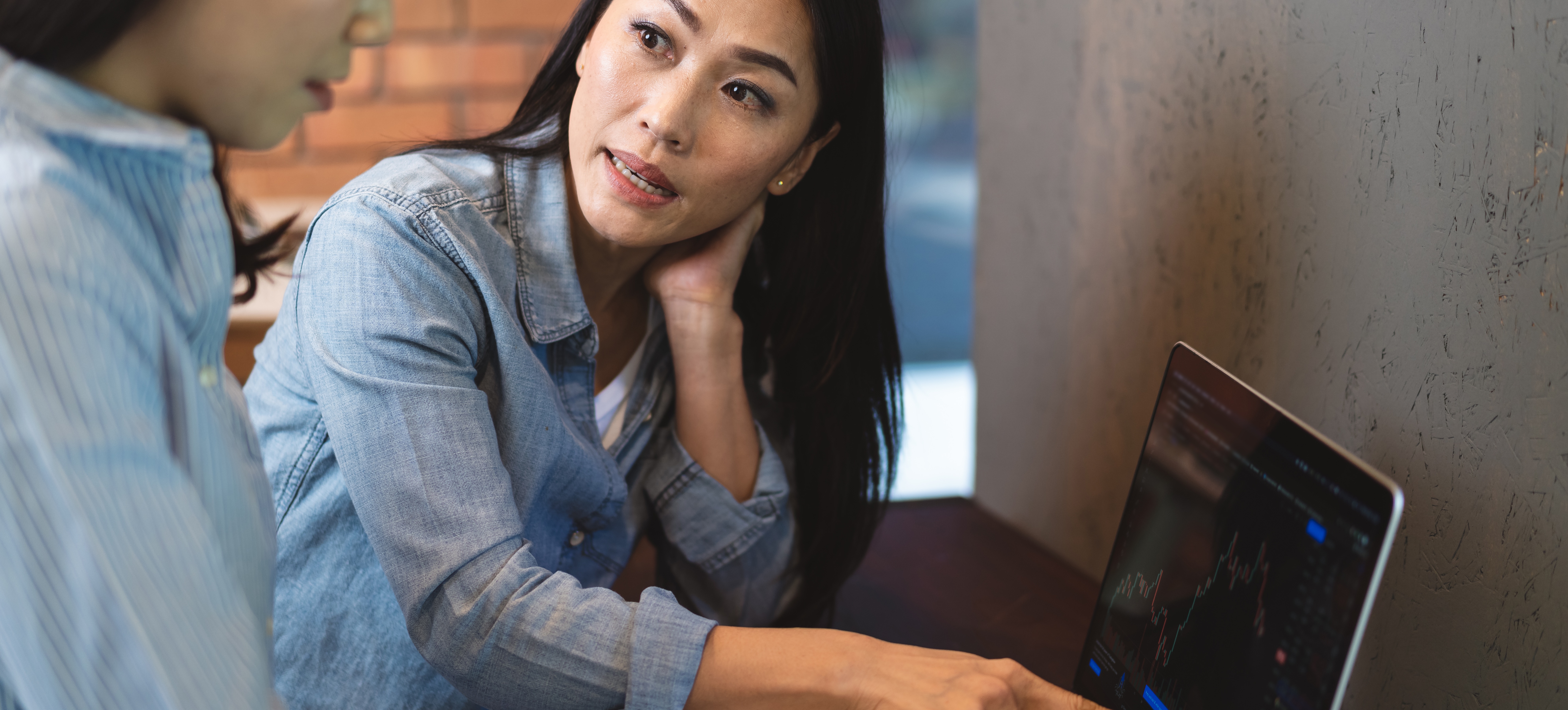 [Featured image]: Two financial analysts seated at a computer in their office, using machine learning for risk management.