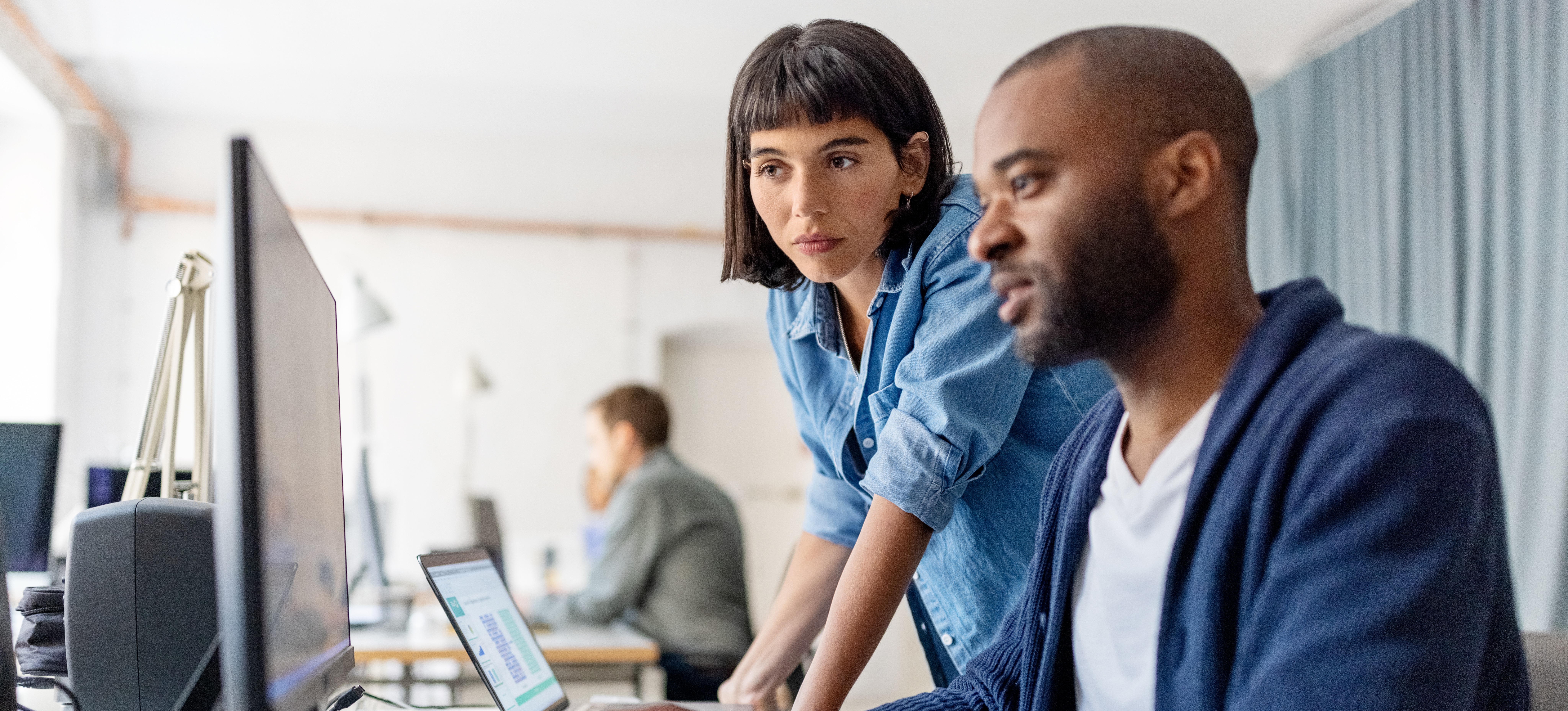 [Featured image: Two engineers work at a computer and use their NLP skills to improve an AI model.]
