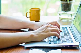 [Featured Image] An employee works on data enrichment on their laptop for their business. 