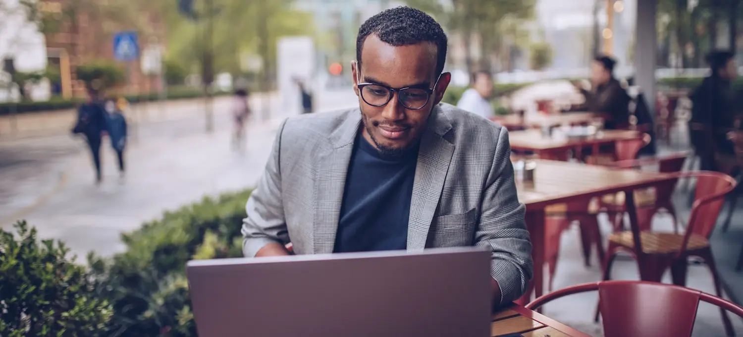 [Featued image] An IT specialist is working at a cafe and researching binary code. 