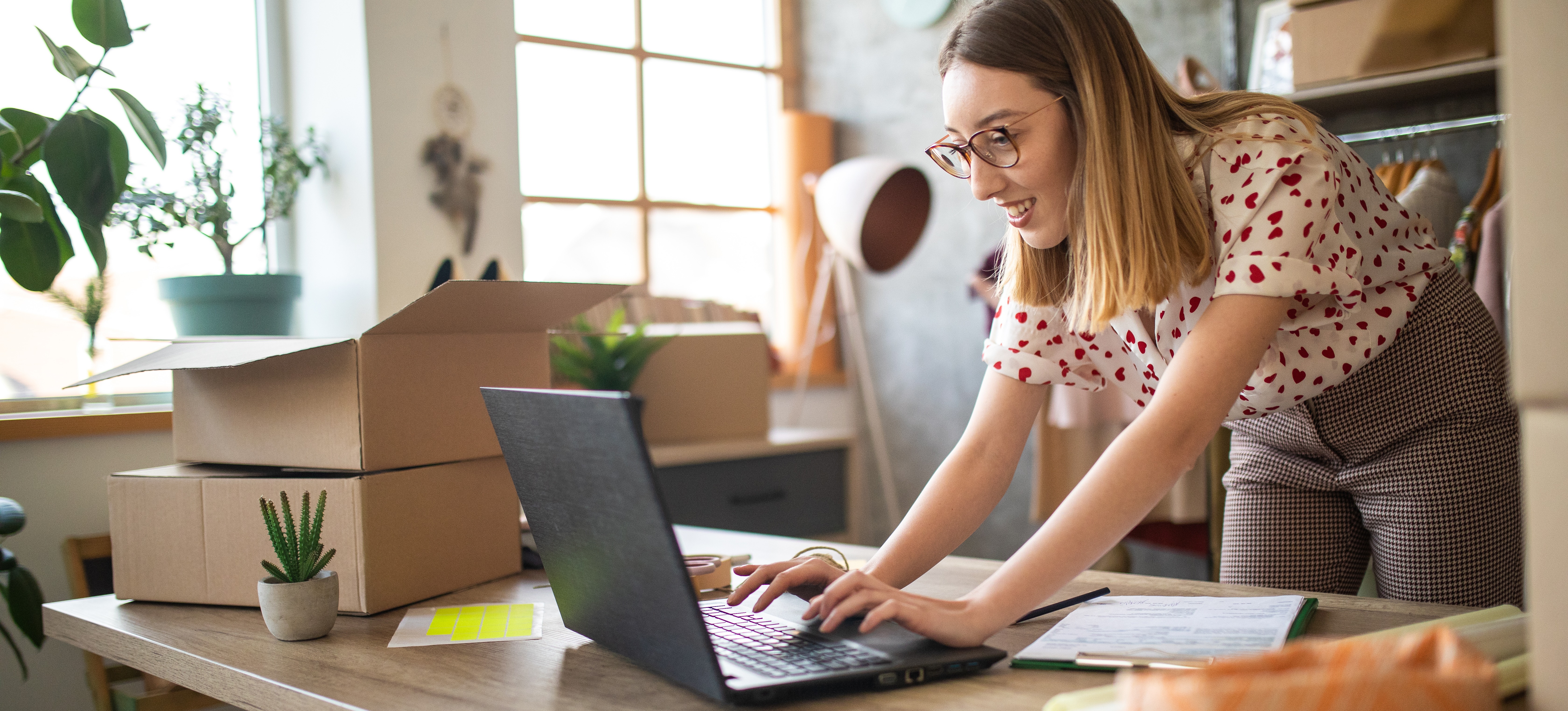 [Featured Image] A person works on a laptop in a small store. 