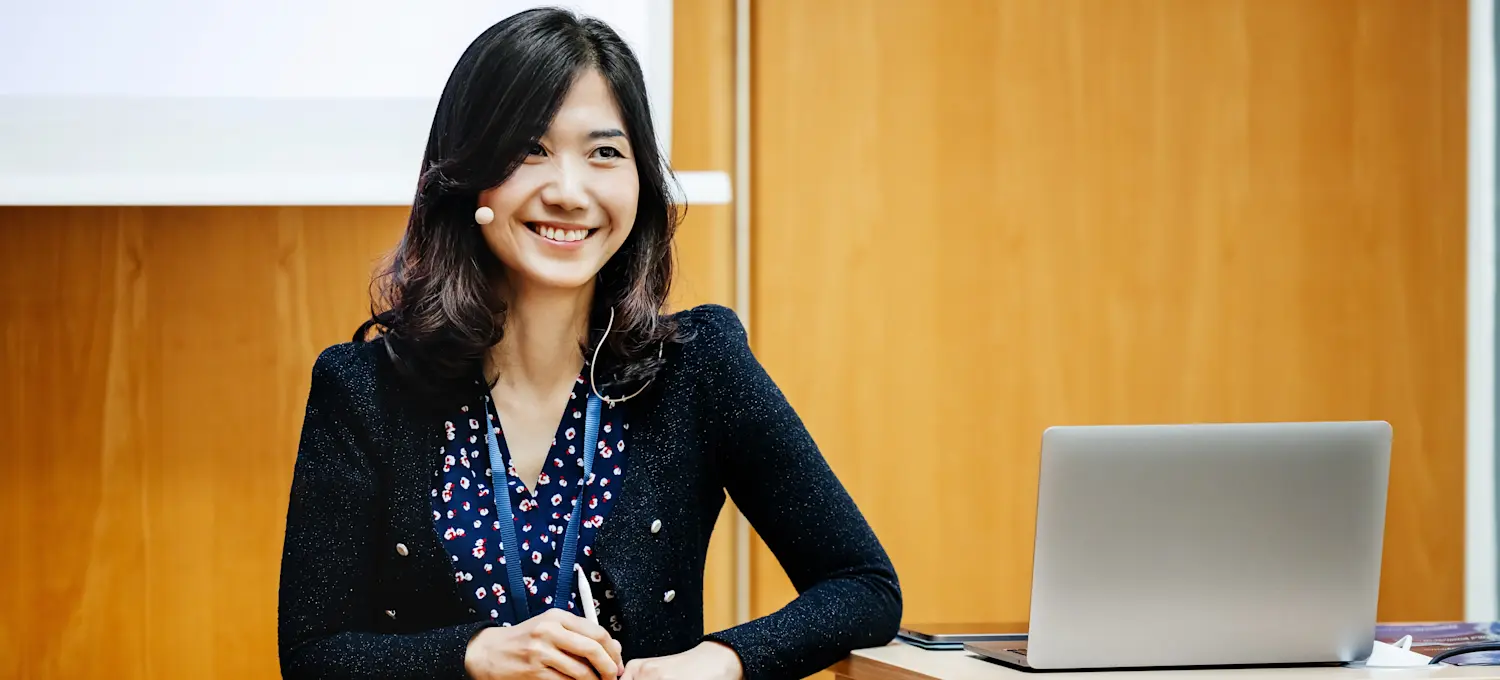 [Featured Image] An Agile coach stands at a podium, leading a training session.