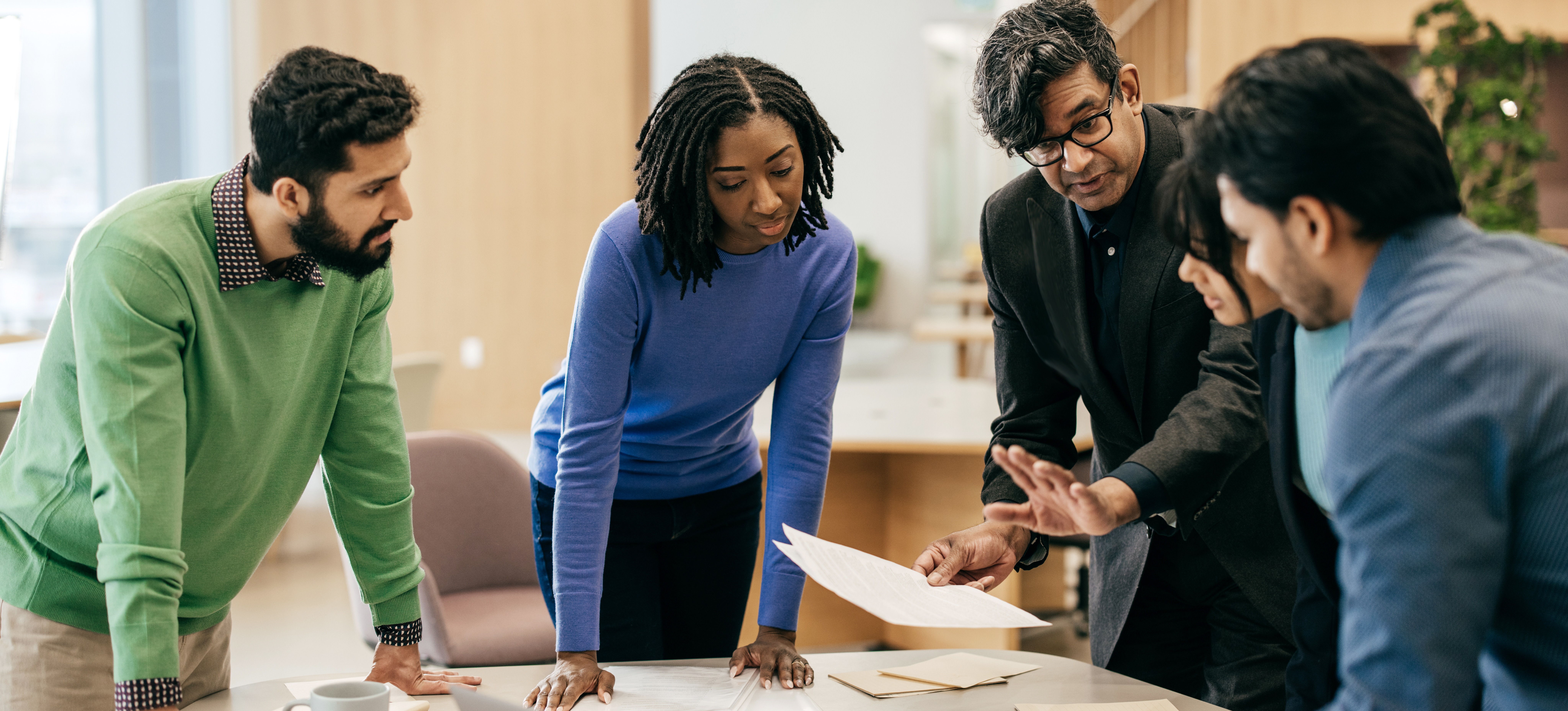 [Featured Image] Colleagues meet to discuss a challenge in their project and use critical thinking skills to help devise a solution. 
