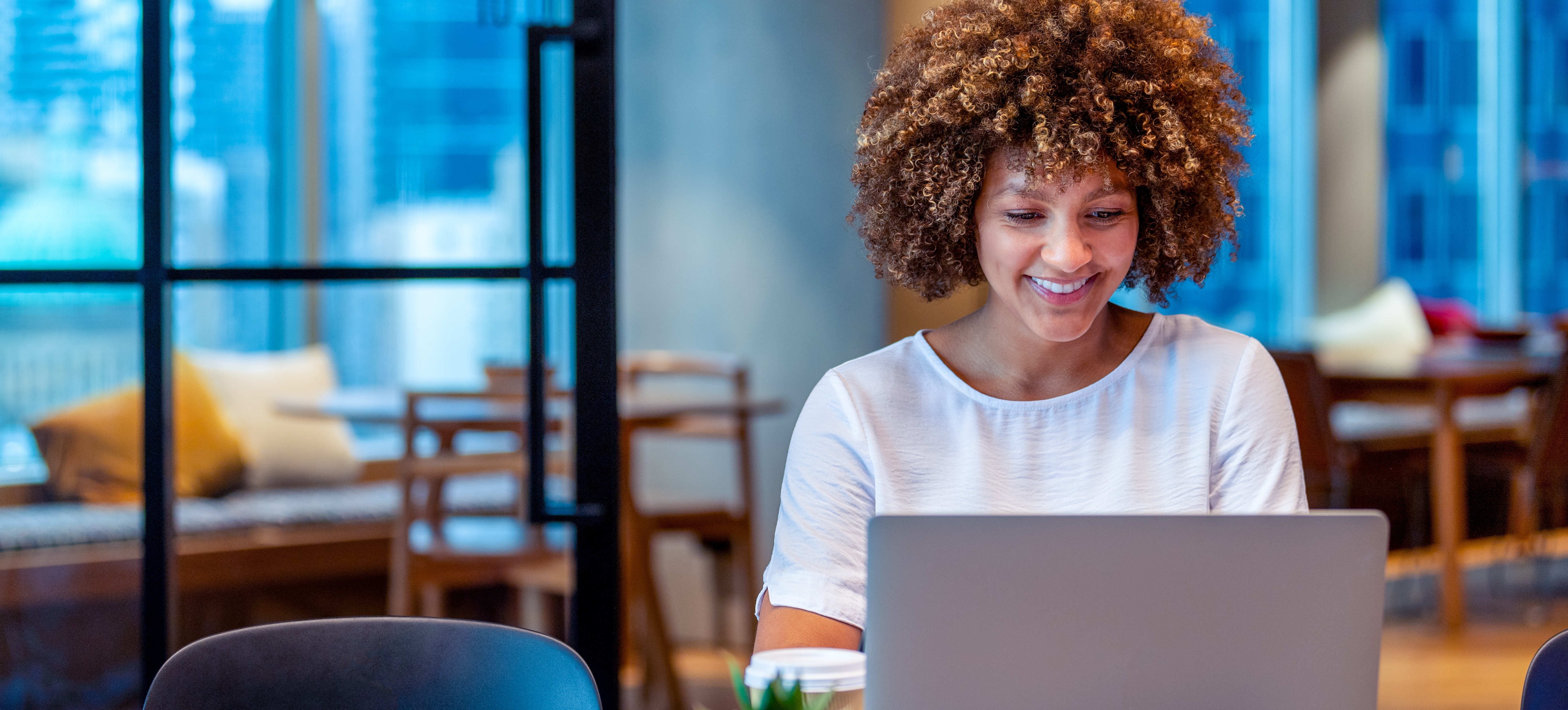 [Featured Image] A person works on their PCM Digital Marketing certification on their laptop in a modern office.
