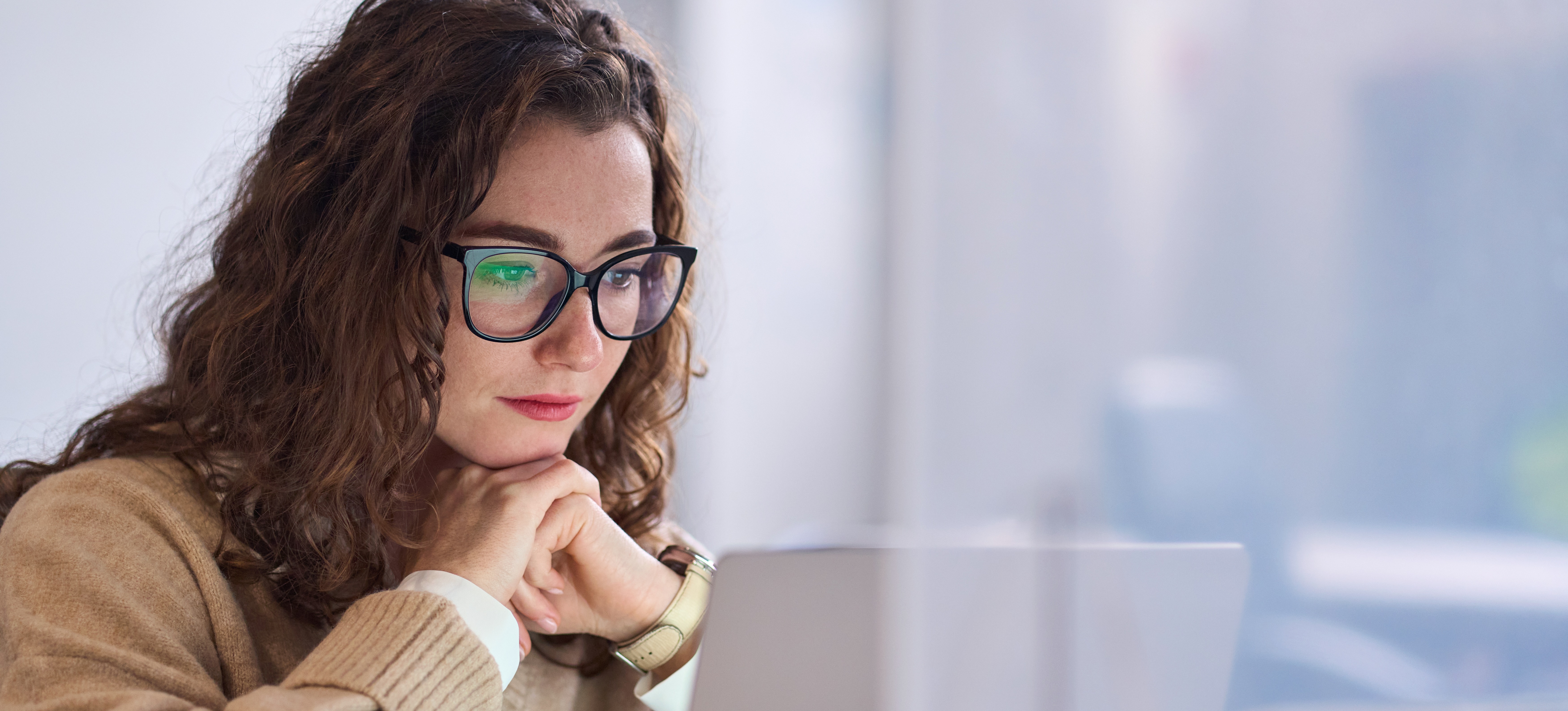 [Featured Image] A woman focused intently on her computer, studying for the GMAT.
