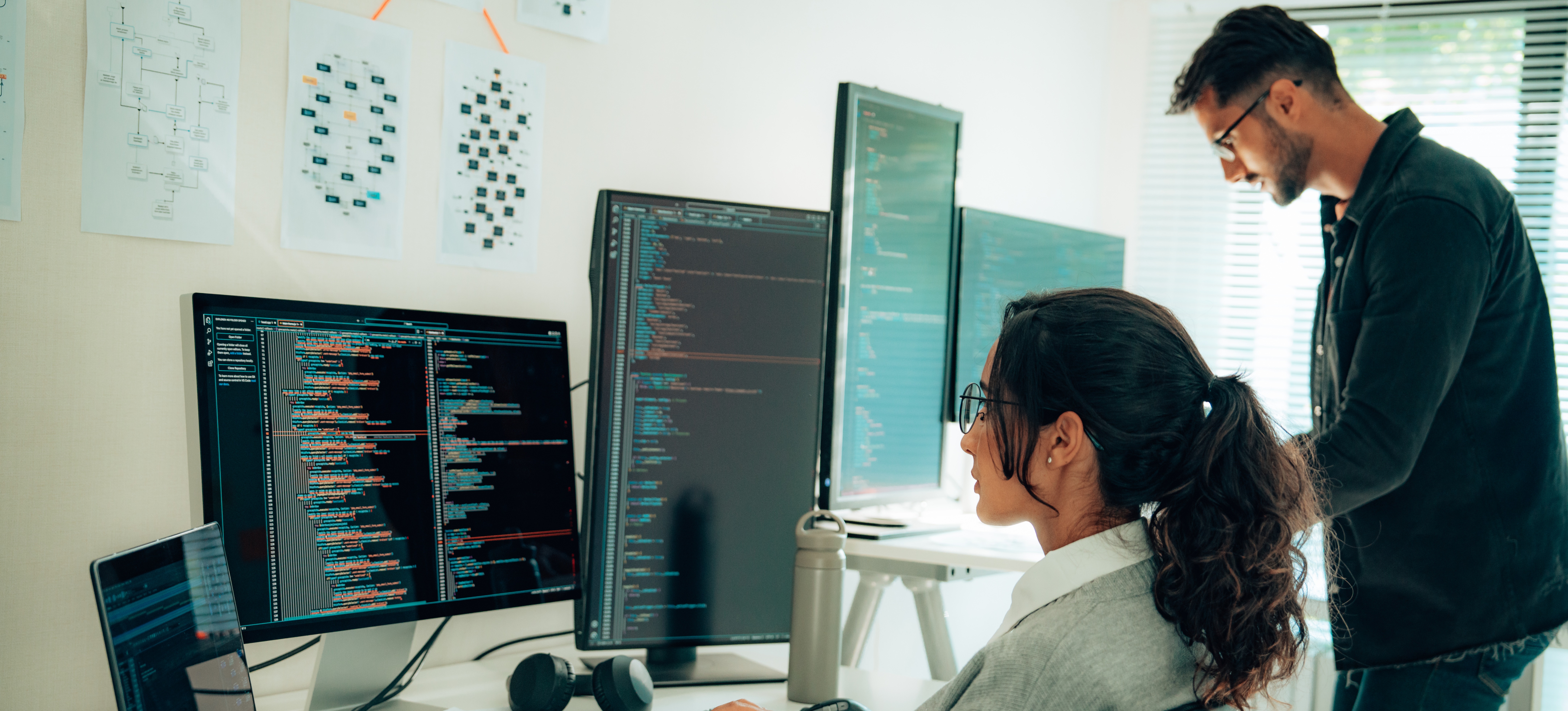 [Featured Image] Two programmers working together in an office learning how to become an AI engineer.
