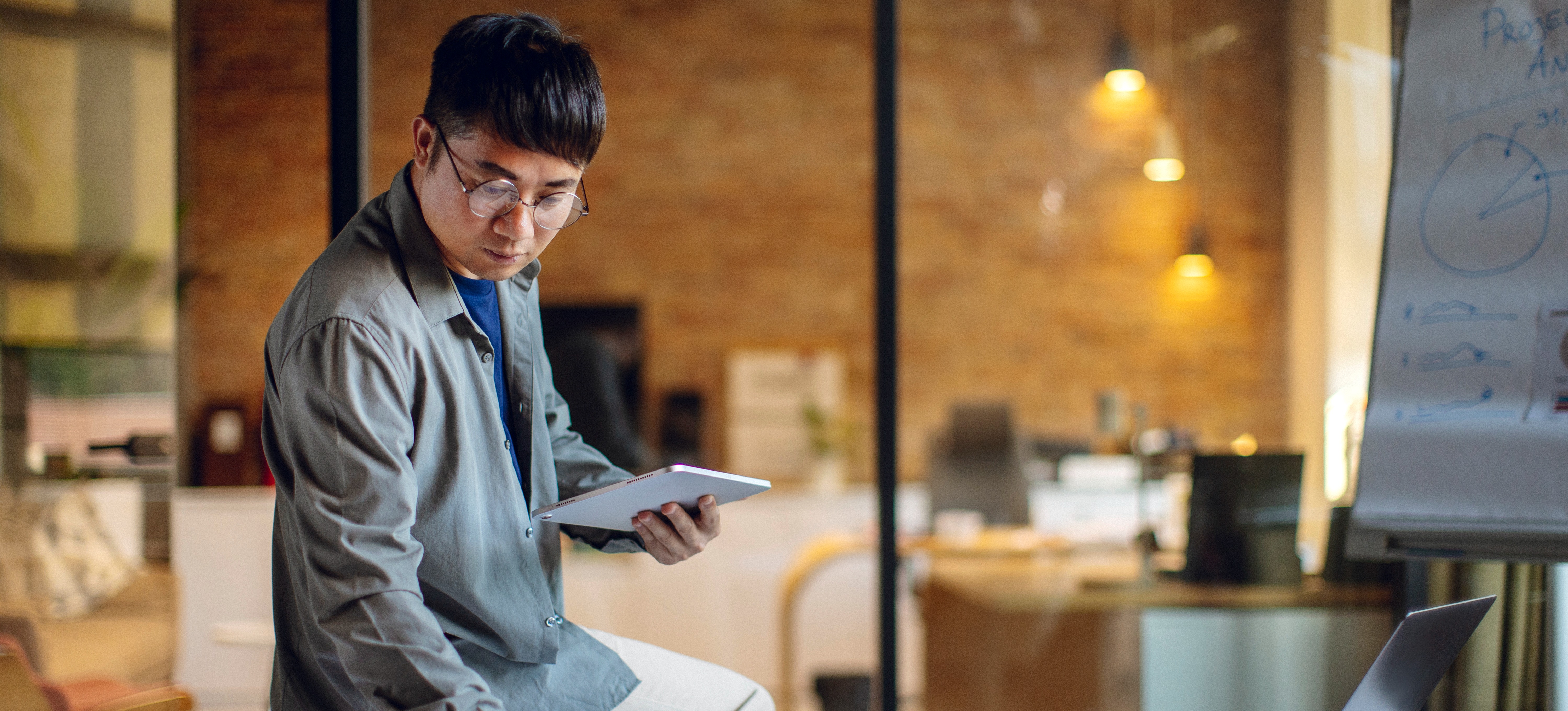 [Featured Image]: A statistician specializing in environmental statistics leans on a table while reviewing data collected by an organization.
