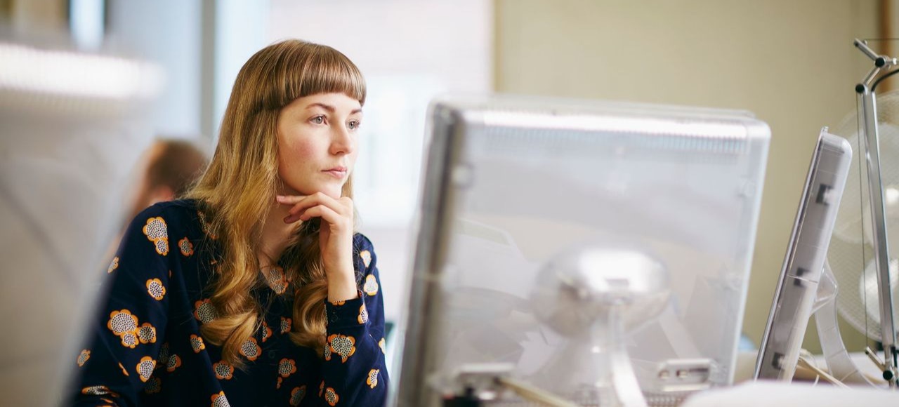 [Hauptbild] Eine UX-Designerin untersucht an einem Desktop, welche Arten von unterstützender Technologie sie in ein Produkt integrieren muss.