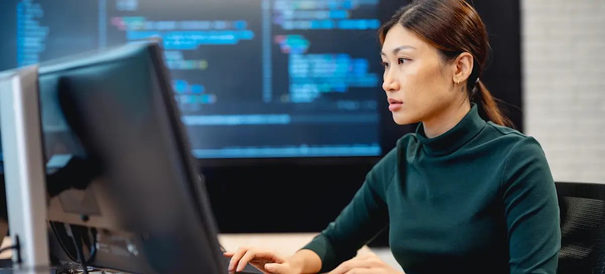 [Featured Image] A developer works at a computer, using the A* algorithm to improve efficiency.

