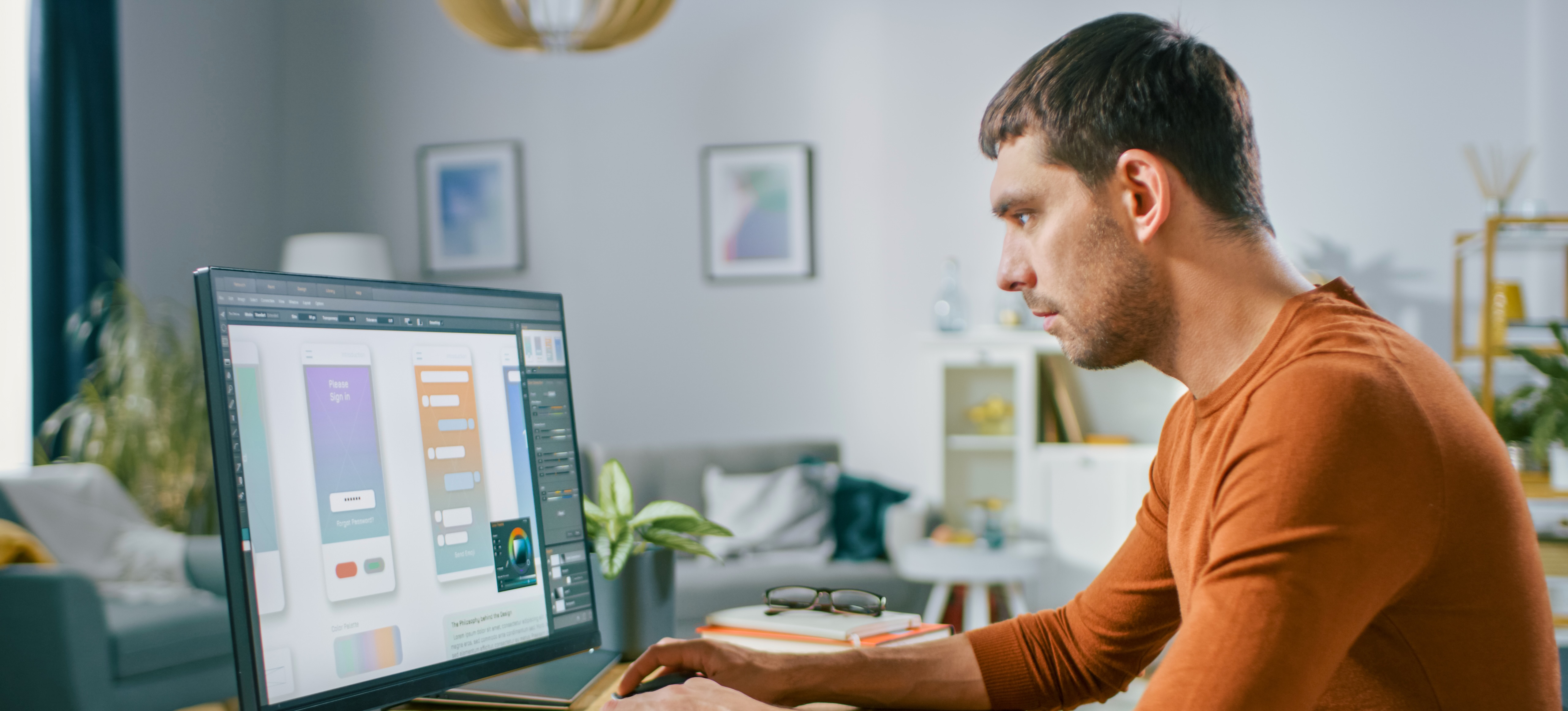 [Hauptbild] Ein UX-Designer arbeitet in einem Büro an seinem Laptop, um die beste Informationsarchitektur für die mobile App seines Unternehmens zu finden.