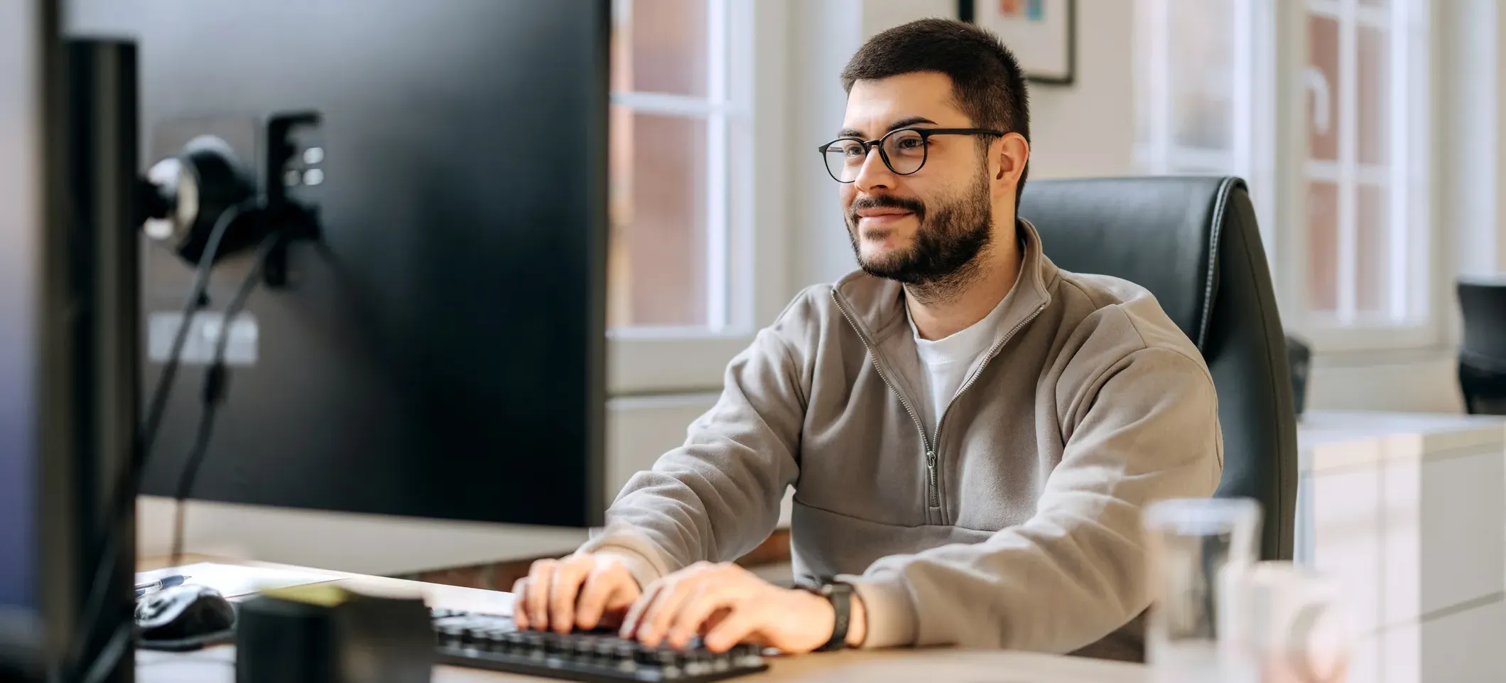 [Featured Image] A smiling developer is learning how to use Google ADK while working at their computer.
