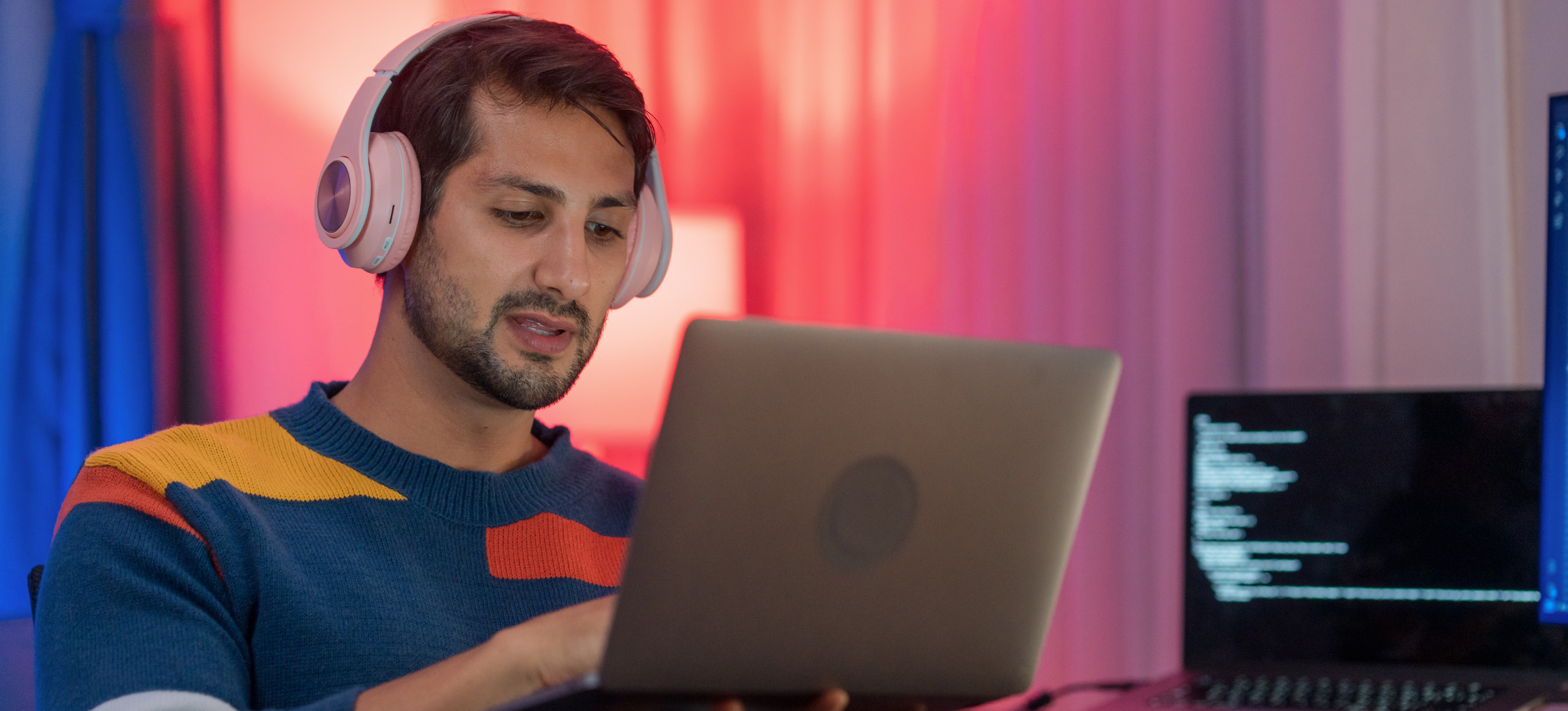 [Featured Image]: A person wearing headphones uses a laptop to find out what is pandas in Python before starting a data analysis project.
