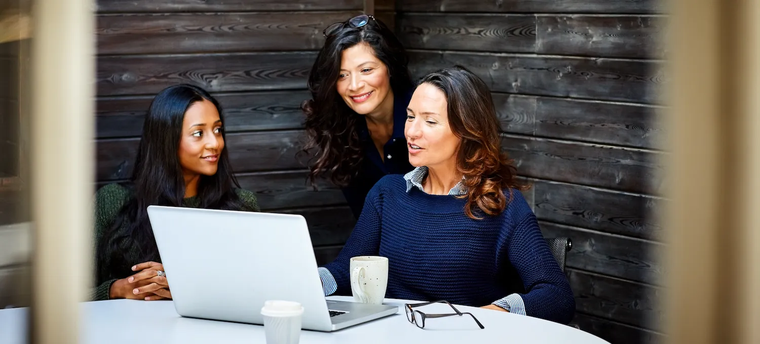 [Featured image] An intrapreneur shows a business proposal to two colleagues on their laptop.