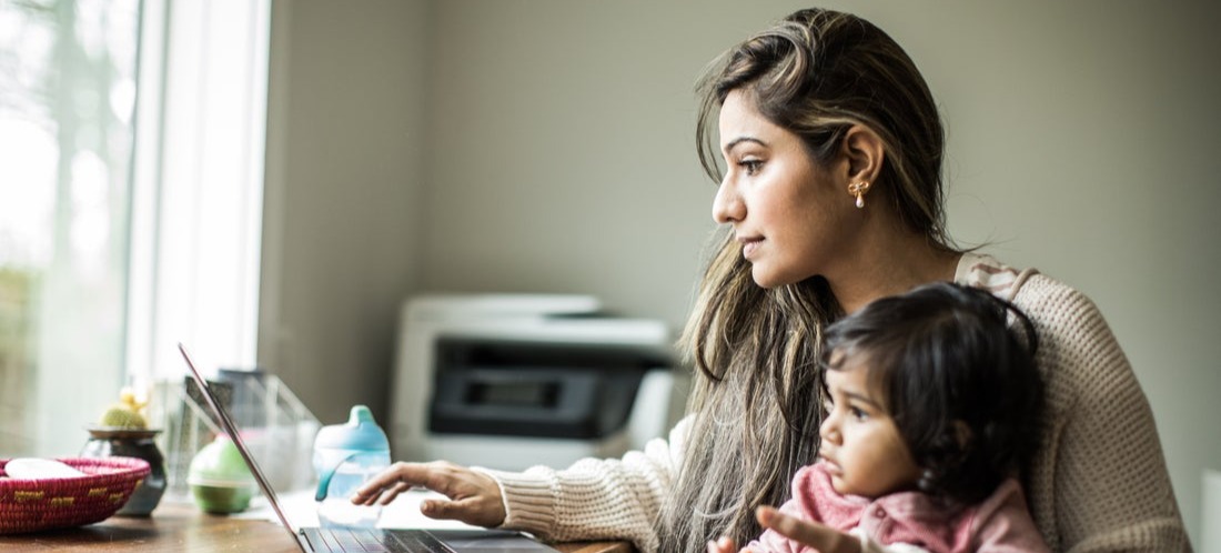 [Image en vedette] Un parent tient son bébé sur ses genoux pendant qu'il utilise l'IA générative sur son ordinateur portable pour créer une liste de jeux amusants à jouer avec son enfant.
