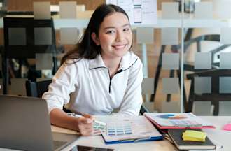 [Featured Image] A woman works at a desk.