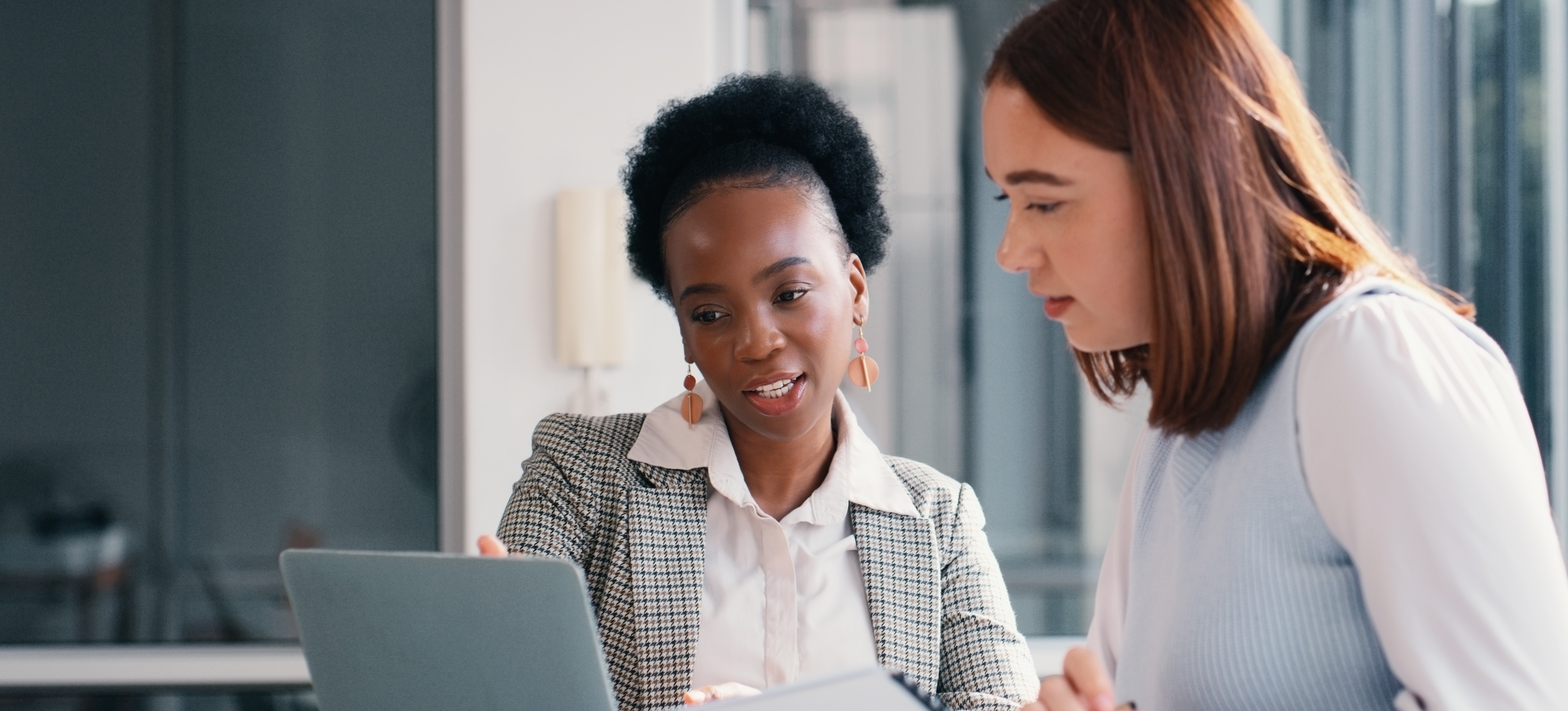 [Featured image]: Two human resource workers at a laptop, deciding how RPA and workflow automation can help increase productivity.
