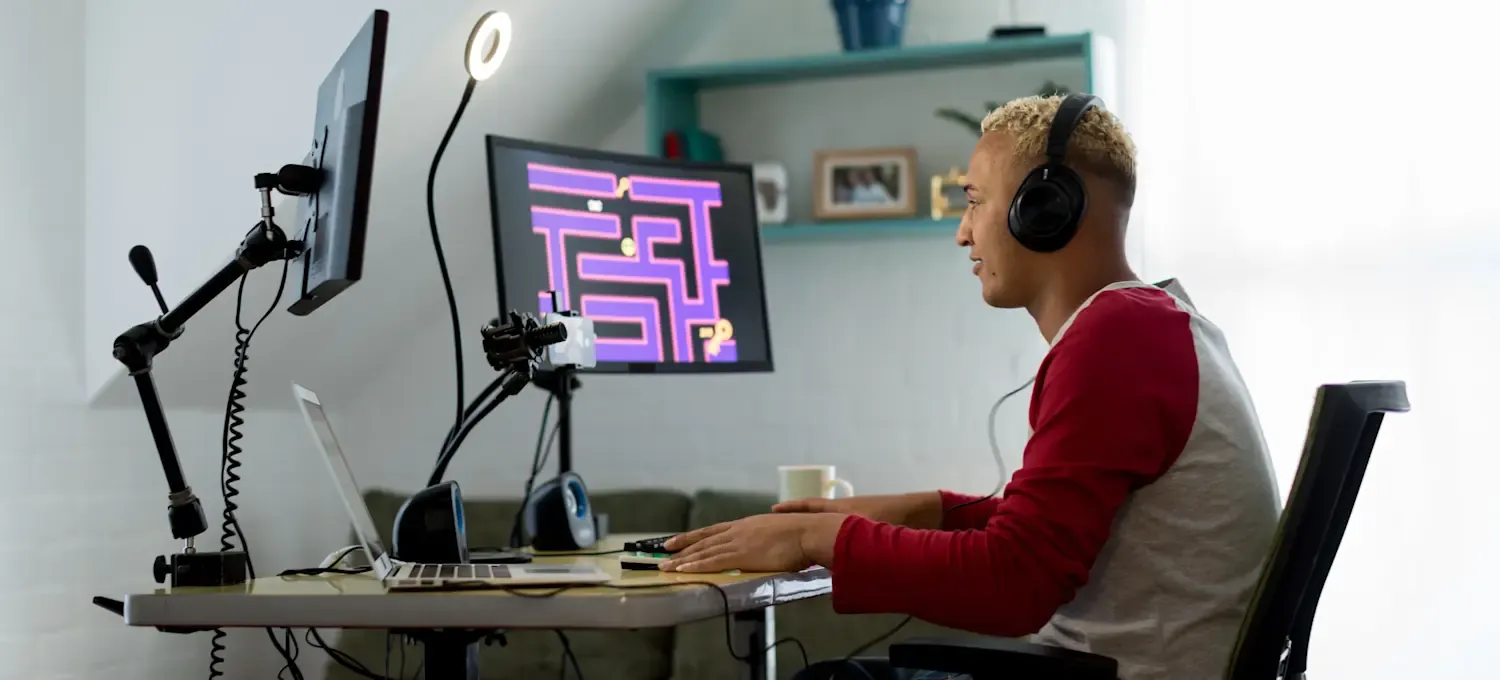 [Featured Image]: A game developer in a professional workspace, smiling while working on AI-driven game development.
