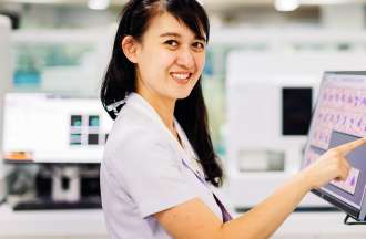 [Featured image] A medical technologist touches a monitor in a hospital setting.