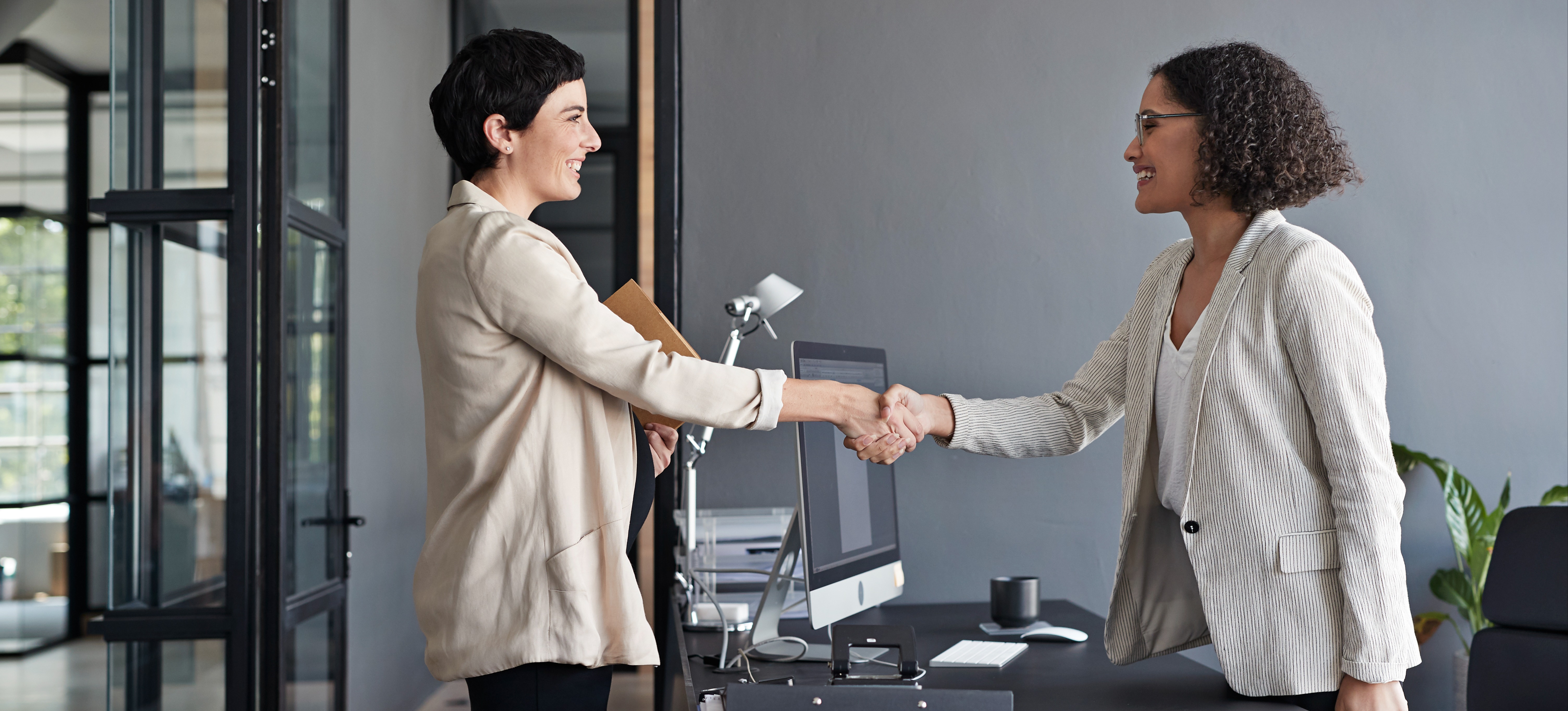 [Featured Image] A successful neural network interview concludes with a handshake between two professionals in a workplace setting.
