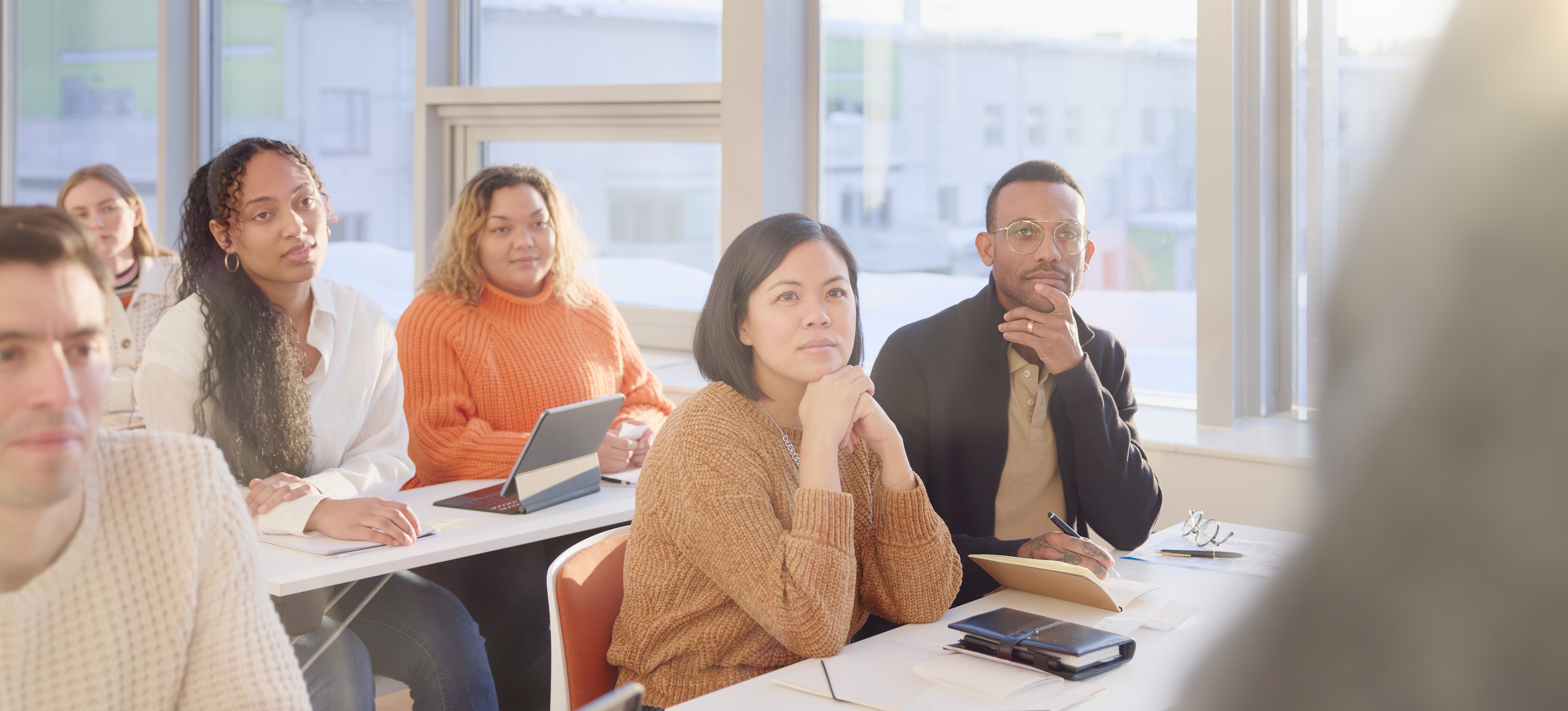 [Featured Image] A group of businesspeople attend a workshop for professional development paid for with an education stipend.
