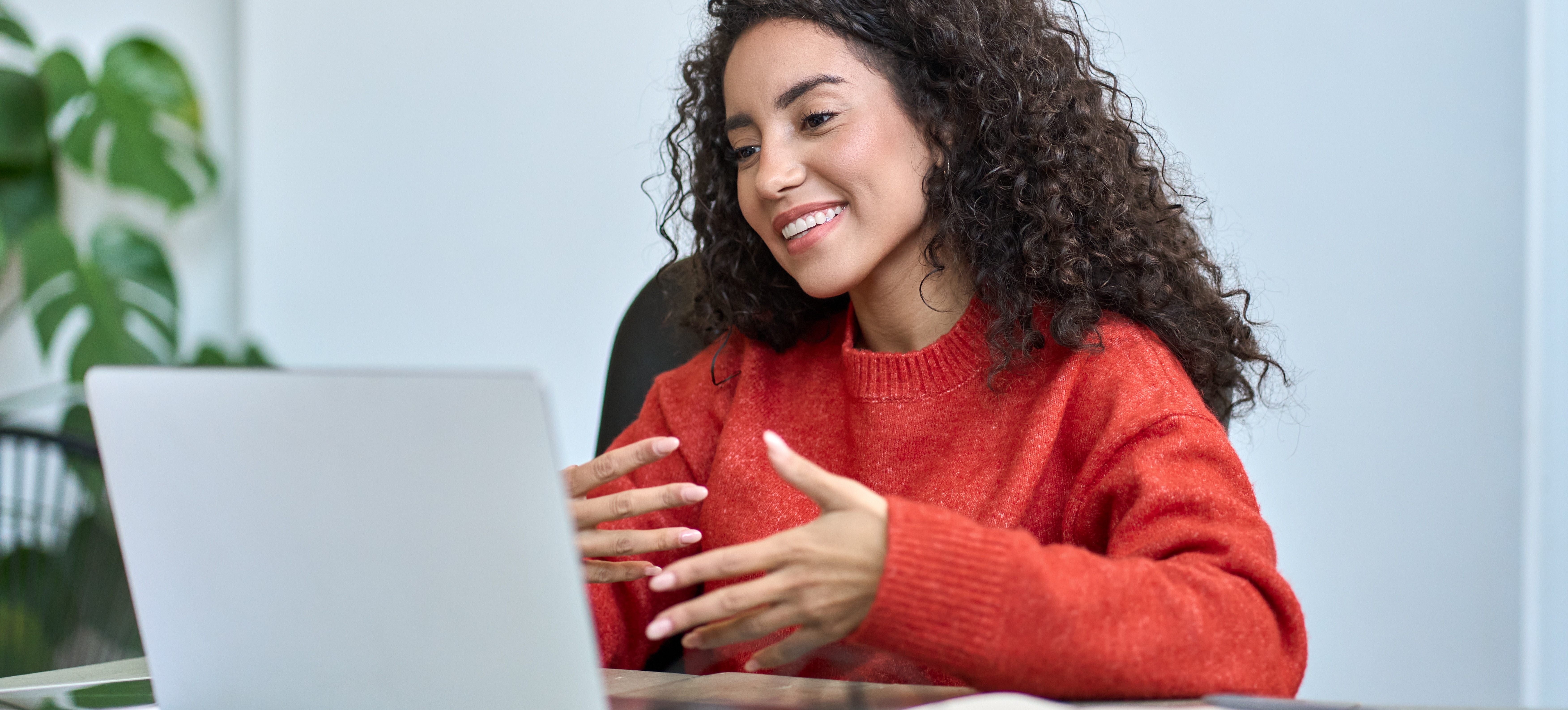 [Featured image] A person in a red sweater practices a mock interview on a laptop computer.