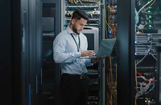 [Featured Image} A person working in cybersecurity looks at a laptop with a key AI application.