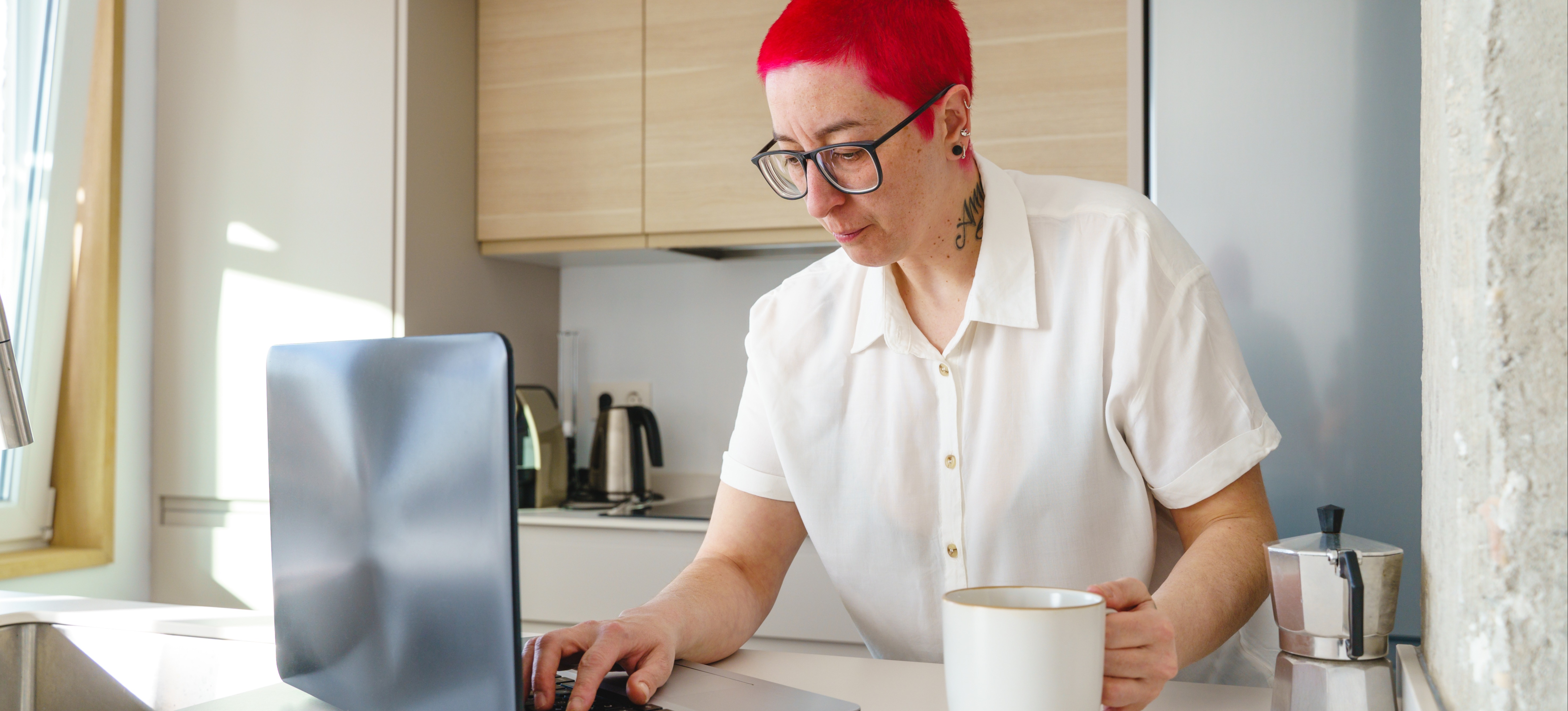 [Featured Image] A job seeker sits in their kitchen and uses a laptop to research a CV template. 