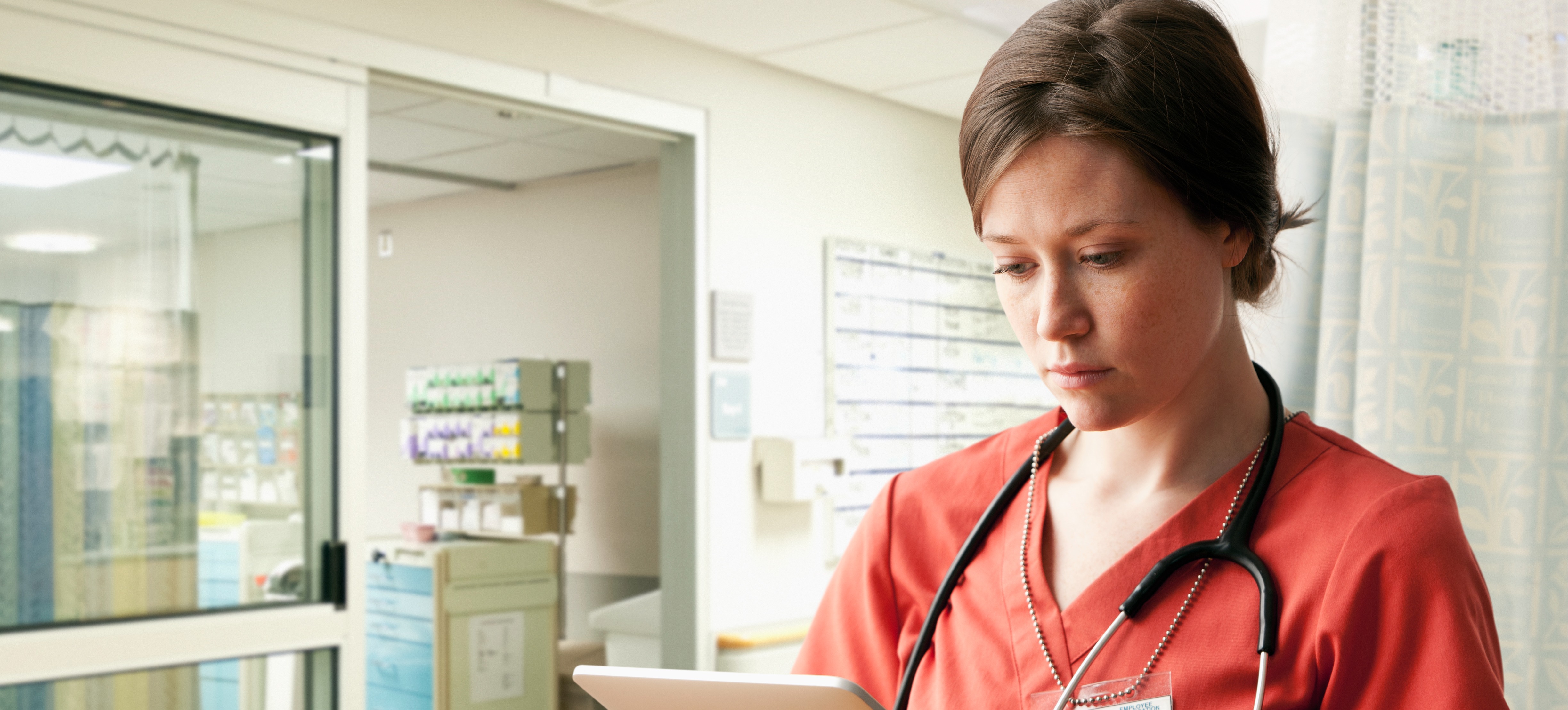 [Featured Image] A nurse case manager consults a tablet, helping to coordinate care for their patients.
