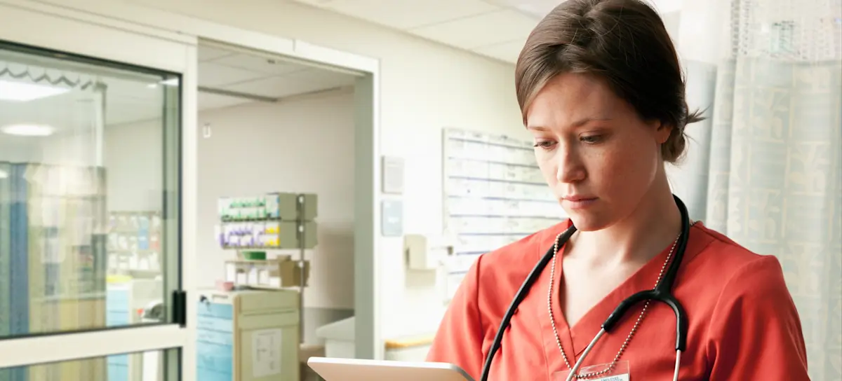 [Featured Image] A nurse case manager consults a tablet, helping to coordinate care for their patients.
