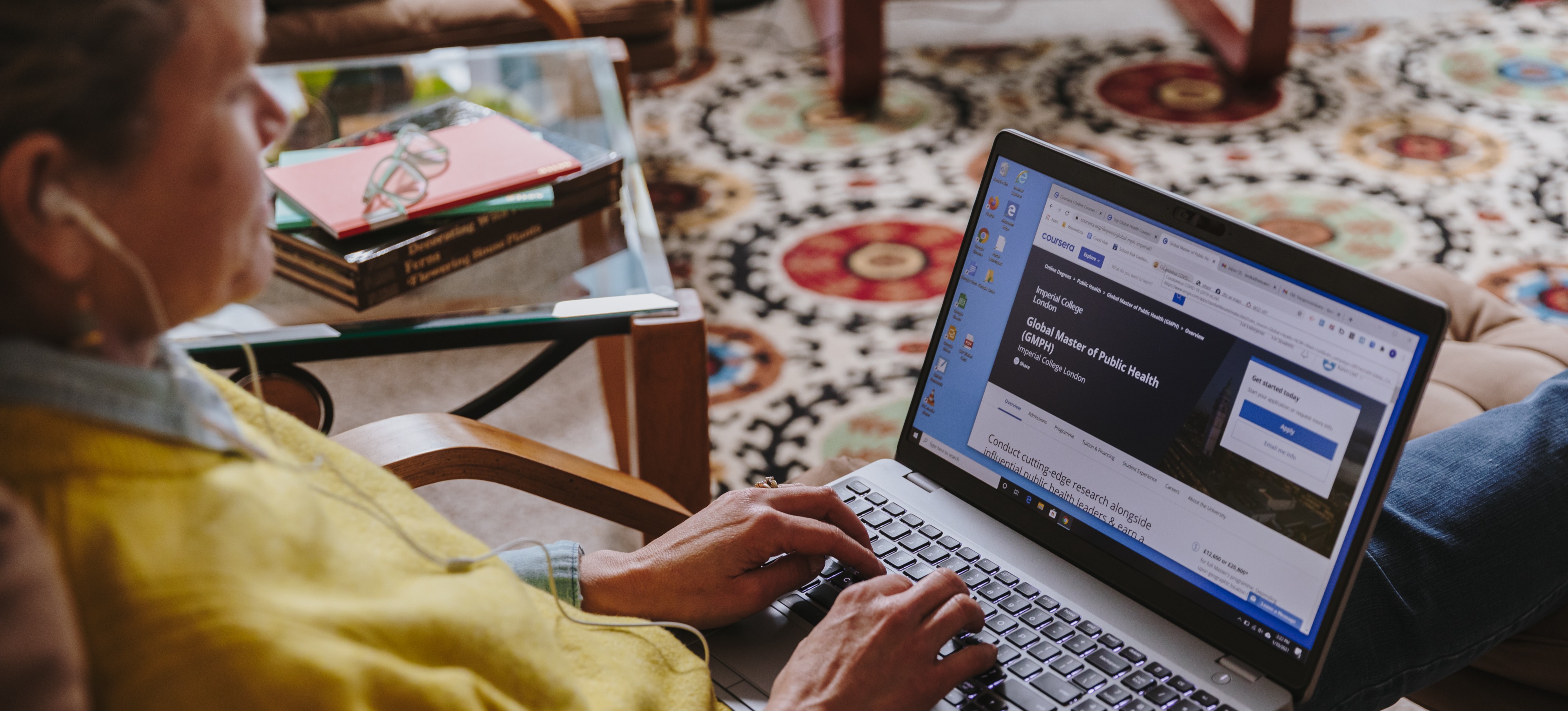 [Featured Image]:  A person wearing a yellow jacket is sitting at their desk working on a laptop computer, performing their duties as an SEO consultant. 