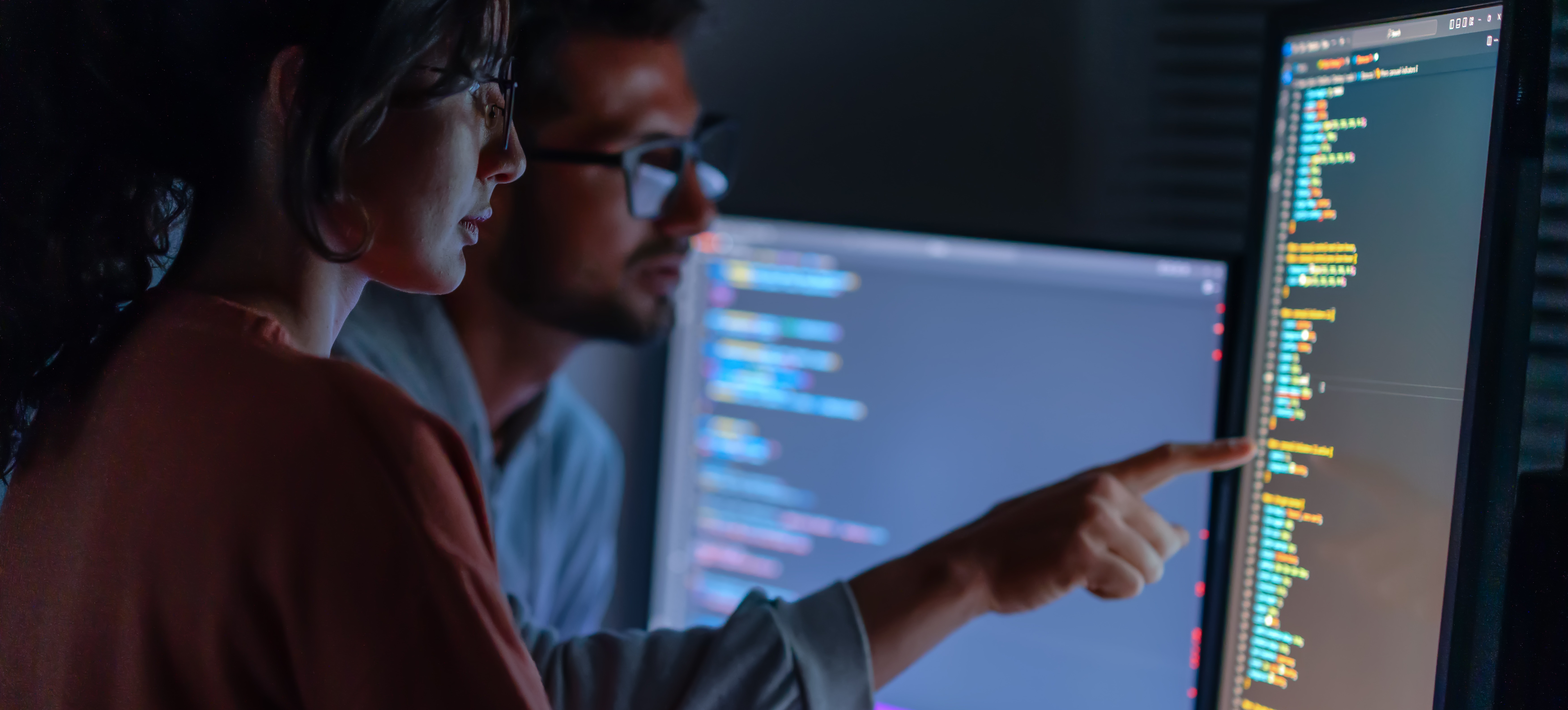 [Featured Image] Two programmers look at a computer screen and discuss beam search.
