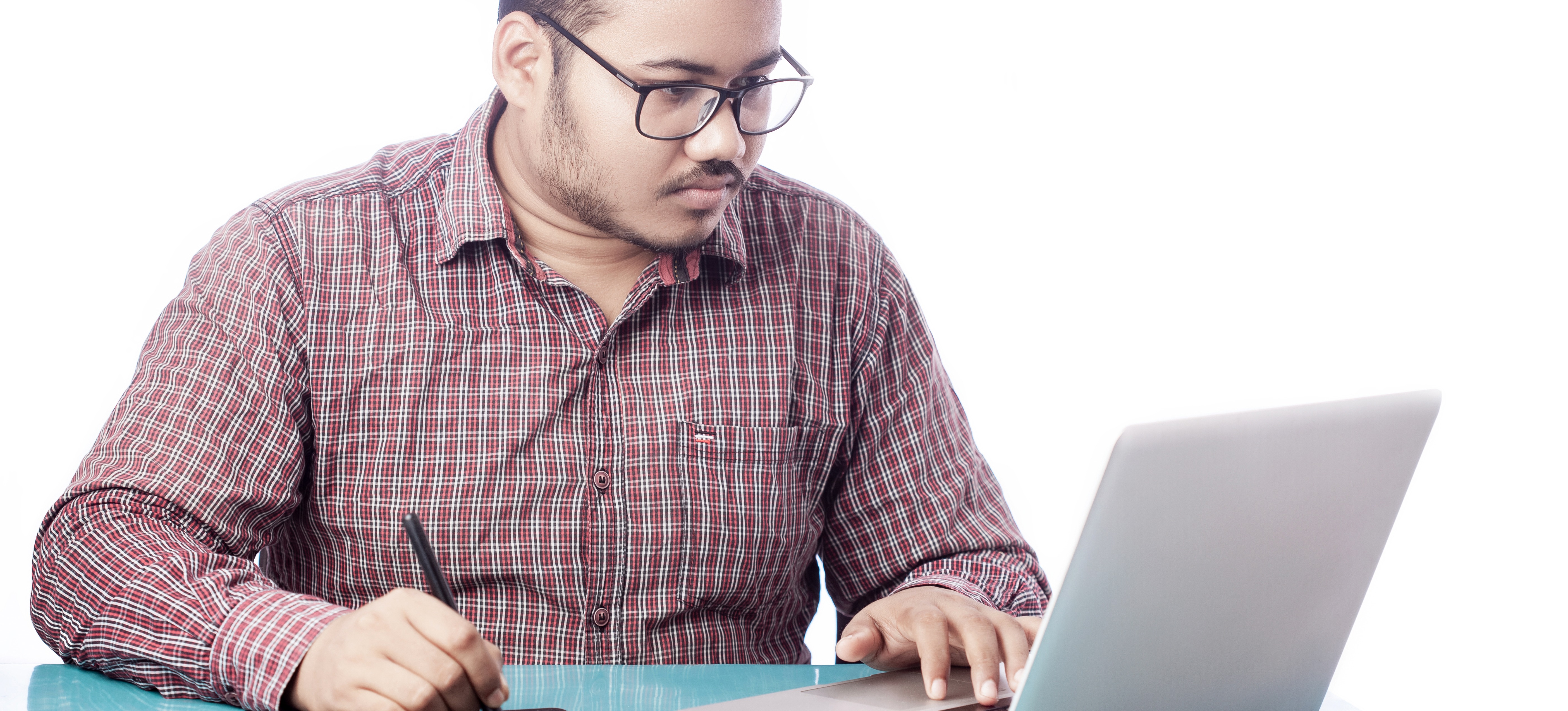 [Featured Image]: A professional uses a laptop and a tablet to work on a graphic design project for work.