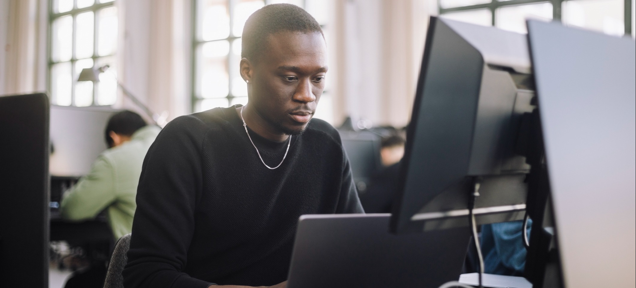 [Image en vedette] Un data scientist travaille sur un ordinateur de bureau dans un bureau.