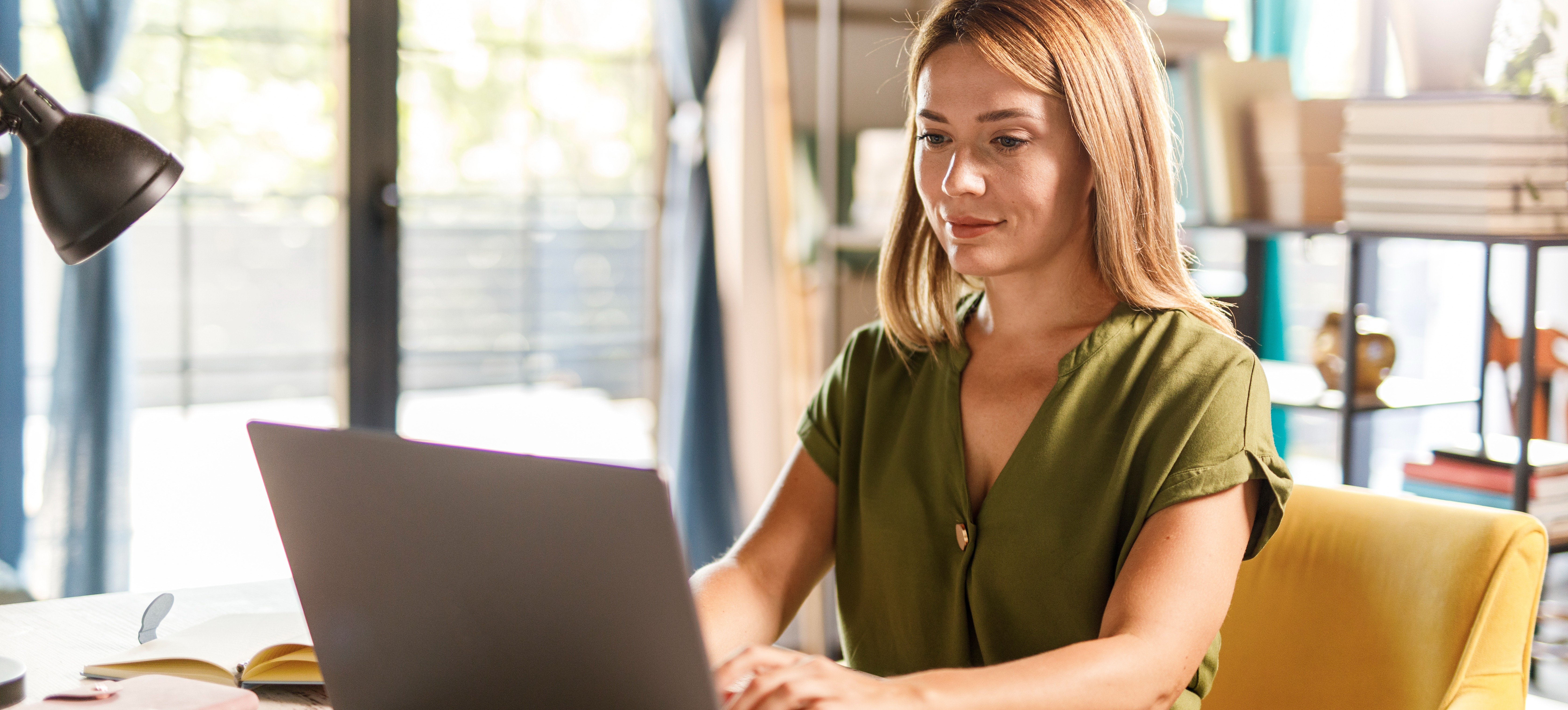 [Image en vedette] Une femme effectue une recherche sémantique sur son ordinateur portable dans son bureau à domicile.
