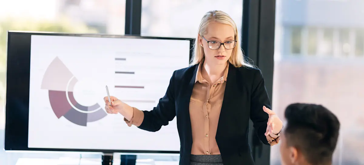 [Featured Image] A project manager presenting data analysis during a meeting in a professional environment, discussing key aspects of model evaluation techniques and performance metrics in machine learning.
