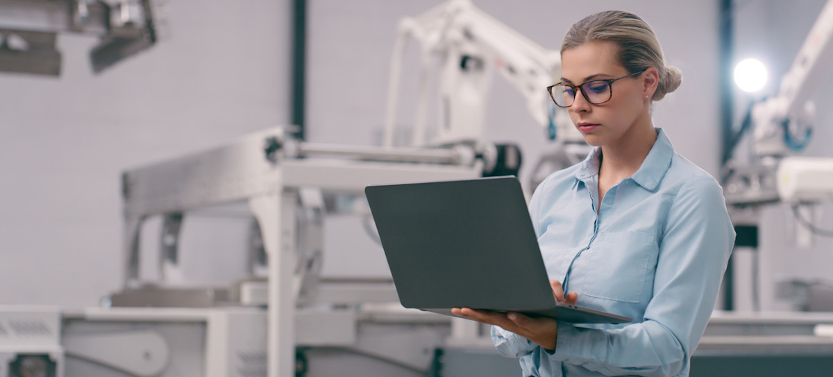 [Featured Image] An engineer working on their laptop decides between using supervised versus unsupervised learning methods for their machine learning tasks as they stand in a robotics lab.
